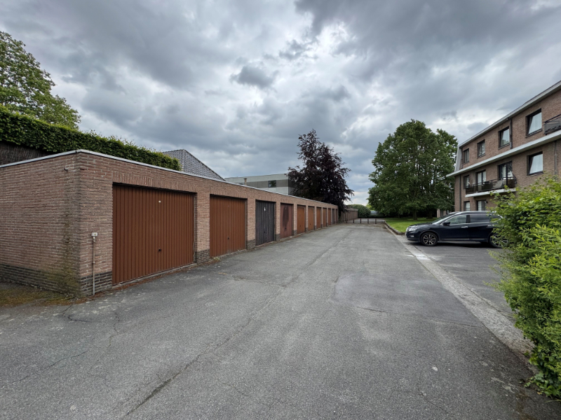 Deze gemetste garagebox met kantelpoort is gelegen op Kerkplein 14.Achter de appartementsgebouwen die zich vlak achter de Kerk bevinden.