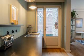 Wonen in de charmante Harmoniewijk? Dit lichtrijke hoekappartement combineert karaktervolle elementen met hedendaags comfort, op een toplocatie vlak bij het stadscentrum (mobiscore: 9.7)! <br /><br />Kijkweekend op zaterdag 7/03 en zondag 8/03.<br /><br />Bezoeken uitsluitend op afspraak via de online agenda:<br />https://calendly.com/delphinejacquemart/30min<br /><br />✔ Instapklaar<br />✔ Ruime leefruimte en kamers<br />✔ Mooie visgraat parketvloeren<br />✔ Zuidwestgericht balkon met groen uitzicht<br />✔ Lift aanwezig<br />✔ Inbouwkasten, private kelder &amp; indoor fietsparking<br /><br />TOPLIGGING<br />Gelegen in een van de meest geliefde buurten van de stad, grenzend aan het Zuid. Op wandelafstand van winkels, supermarkten, Velo-station, openbaar vervoer, parken en gezellige lunchadresjes. Het stadscentrum bereik je moeiteloos te voet, en dankzij de vlotte in- en uitvalswegen ben je snel de stad in en uit.<br /><br />LICHTRIJK<br />Het appartement bevindt zich op de derde verdieping van een kleinschalig gebouw (7 appartementen) met lift, op de hoek van de Peter Benoitstraat en de Van Schoonbekestraat. Dankzij de hoekligging geniet je hier van uitzonderlijk veel licht.<br /><br />Via de stalen veiligheidsdeur kom je binnen in de inkomhal met vestiaire en apart toilet. De ruime leefruimte (32 m²) met visgraat parket en open indeling voelt aangenaam en ruim aan – ideaal om te ontspannen of gasten te ontvangen.<br /><br />De open keuken is volledig uitgerust met een 5-pits SMEG gasfornuis, oven, vaatwasser, dampkap, koelkast en diepvriezer, en biedt veel bergruimte. Aansluitend vind je het gezellige zuidwestgerichte balkon met zicht op groen – een heerlijke plek om van de zon te genieten.<br /><br />2 VOLWAARDIGE KAMERS<br />Beide kamers zijn ruim genoeg voor een dubbel bed en flexibel in te richten als slaapkamer, bureau of logeerkamer. Momenteel wordt één kamer gebruikt als bureauruimte met sofa-bed.<br /><br />PRAKTISCHE BADKAMER &amp; BERGRUIMTE<br />De badkamer beschikt over een ruime inloopdouche en een ingebouwde kast met aansluiting voor wasmachine. Daarnaast is er een ruime private kelder (10m²).