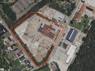 Volledig verhard bedrijventerrein van 16.795 m2 met loodsen en industriële tenten in Zonhoven.