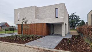 Ruime nieuwbouwwoning met 3 slaapkamers ,  luxueus afgewerkt .<br /><br />Indeling : Inkomhal , apart toilet , berging , woonkamer met open keuken , terras en tuin . <br />Verdiep : 3 ruime slaapkamers waarvan 1 met dressing , badkamer met bad en douche  , apart toilet , berging . <br /><br />Oprit met inpandige carport . <br />Tuin aangelegd + terras voorzien .<br />Vloerverwarming + warmtepomp .<br />11 Zonnepanelen voorzien . <br />Garage/tuinberging bereikbaar via achtergelegen straat .<br />Pre-airco installatie .<br />Woning is volledig geschilderd .<br /><br />Maak snel een afspraak om deze unieke woning te bezoeken . <br /><br /> 