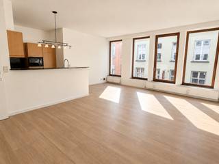 In de bekende Hoogstraat, in het hart van Antwerpen, bevindt zich dit uitstekend gelegen appartement. De vele restaurants, cafés en winkels maken van deze bruisende buurt een top locatie.<br /><br />Het appartement van ca. 89 m² is gelegen op de tweede verdieping. Dankzij de kamerhoge raampartijen geniet de woonruimte van een aangename lichtinval. De hoogwaardige, onderhoudsvriendelijke PVC-parketvloer zorgt voor een warme en ruimtelijke uitstraling.<br /><br />De open keuken is recent uitgerust met splinternieuwe toestellen: een kookplaat, heteluchtoven, vaatwasser, koelkast met ruim vriesvak en een microgolfoven. De hoge toog vormt een subtiele scheiding tussen de keuken en de leefruimte en creëert zo een ideale balans tussen openheid en functionaliteit.<br /><br />De masterbedroom bevindt zich aan de rustige achterzijde. Ook de tweede slaapkamer is ruim en leent zich perfect als logeerkamer, kinderkamer of bureau. Beide kamers maken gebruik van de badkamer, uitgerust met een ligbad met douche en een dubbele lavabo. Hier is tevens een aansluiting voorzien voor een wasmachine en droogkast.<br /><br />De gemeenschappelijke binnentuin biedt een oase van rust, waardoor u even vergeet dat u zich in het centrum van Antwerpen bevindt.<br /><br />Een ondergrondse autostaanplaats dient worden bijgehuurd voor € 130 per maand.<br /><br />Gemeenschappelijke kosten: 130 Euro per maand.<br />Provisie op verbruik van water: 35 Euro per maand.<br />Nutsvoorzieningen gas en elektriciteit zijn privé op te nemen door de huurder.<br /><br />Onmidellijk beschikbaar.