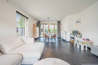 <p>Op zoek naar een ruime, instapklare woning op één van de mooiste locaties van Temse? Deze halfopen bebouwing in de gegeerde wijk De Zaat combineert 220 m² wooncomfort met een bijzonder rustige ligging op amper 100 meter van de Scheldedijk. Met 4 slaapkamers, een afgewerkte zolder, EPC A, zonnepanelen en een zonnige tuin is deze woning helemaal klaar voor de toekomst.</p><p>De woning werd gebouwd in 2011 en is tot in de puntjes verzorgd. Via de ruime inkomhal met ingemaakte kasten en een apart gastentoilet bereik je de royale leefruimte. Grote raampartijen langs drie zijden zorgen hier de hele dag voor veel natuurlijk licht, terwijl airconditioning het hele jaar door voor een aangenaam binnenklimaat zorgt.</p><p>Vanuit de woonkamer heb je rechtstreeks toegang tot het terras en de tuin met tuinhuis. Dankzij de noordwestoriëntatie geniet je hier volop van de namiddag- en avondzon.</p><p>De volledig uitgeruste keuken beschikt over een vaatwasser, oven, microgolfoven en koelkast. Aansluitend bevindt zich een praktische en ruime berging met aansluitingen voor wasmachine en droogkast. Via een handige doorloopdeur sta je opnieuw in de inkomhal.</p><p>Op de eerste verdieping bevinden zich 4 volwaardige slaapkamers, waarvan momenteel één kamer ingericht is als dressing. Daarnaast is er een afzonderlijk toilet en een ruime badkamer met ligbad, inloopdouche en dubbel lavabomeubel. Ook op deze verdieping is airconditioning aanwezig.</p><p>Een bijkomende troef is de volledig afgewerkte zolder, bereikbaar via een vaste trap. Deze ruimte kan perfect dienstdoen als thuiskantoor, hobbyruimte, speelkamer of vijfde slaapkamer. Daarnaast is er nog een afzonderlijke bergzolder voor extra opslagruimte.</p><p>Ook op energetisch vlak scoort deze woning uitstekend. Met zonnepanelen, een conforme elektrische installatie, voorzieningen voor een thuisbatterij en een EPC-score A van 73 kWh/m²/jaar is de woning bijzonder energiezuinig. De oprit biedt plaats aan twee voertuigen en beschikt bovendien over een driefase laadpaal.</p>