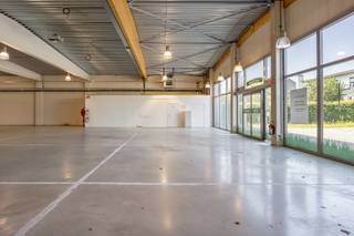 Op een gegeerde zichtlocatie aan de Genkersteenweg 159 in Hasselt bevindt zich dit instapklare en industrieel geïsoleerde winkelpand. Met een terreinoppervlakte van 2.511 m² en een perceelbreedte van 23,53 meter is dit pand volledig omheind en volledig geklinkerd. De locatie is strategisch ideaal: nabij het centrum van Hasselt en vlak bij de belangrijkste invalswegen, wat zorgt voor maximale zichtbaarheid en bereikbaarheid. Het winkelpand heeft een totale bruikbare vloeroppervlakte van 1.141 m² volgens EPC, waarvan circa 650 m² ingericht is als showroom met gepolierde betonvloer en volledige verlichting (dient aangewend te worden in het kader van de bestemming, opslag en showroom). Verder is het pand voorzien van een alarmsysteem, internetvoorziening, aansluiting op aardgas, een goed werkend verluchtingssysteem, een keuken, twee toiletten, een CV-ruimte en twee aparte bergingen. De plafondhoogte bedraagt 5,79 meter met een licht afhellend dak naar de achterzijde toe. De ruime parking biedt plaats voor ongeveer 32 wagens, wat ideaal is voor klanten en personeel. Dankzij de combinatie van oppervlakte, ligging en voorzieningen is dit pand perfect geschikt voor een handelszaak of showroom met professionele uitstraling. De hoofdbestemming is voorbehouden voor ambachtelijke bedrijven en kmo’s (B2B). Een mooie kans voor zij die opzoek zijn naar bedrijfspanden te koop in Hasselt. Relevante documenten zijn eveneens beschikbaar op onze website www.dewaele.com of geef ons een seintje op 011 30 50 50.