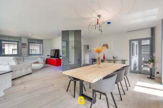 Vlak aan het Pater Vanweertplein te Vlijtingen, deelgemeente van Riemst, bevindt zich deze perfect verzorgde halfopen woning met drie slaapkamers, inpandige garage en fijne tuin op een perceel van 5a 67ca. <br /><br />In deze leuke, autoluwe buurt, net onder de kerktoren van Vlijtingen, ervaart men een aangenaam gevoel van rust en een fijne gemoedelijke sfeer. Tegelijkertijd komt men al snel in het centrum van Riemst met tal van winkels en andere dagelijkse voorzieningen. De basisschool ligt om de hoek. Na een twaalftal minuutjes rijden treft men zowel het centrum van Bilzen als dat van Maastricht. Wie houdt van wandelen, joggen of fietsen in de natuur, kan hier terecht op tal van leuke wandelwegjes, overvloedig te vinden in de nabije omgeving. <br /><br />De woning werd structureel bijzonder degelijk gebouwd eind jaren 80, en daarna voortdurend met de beste zorgen en veel liefde onderhouden. Door de jaren heen mocht dit eigendom een aantal geslaagde renovatie- en verbeteringswerken ondergaan, zoals onder meer de volledige vernieuwing van de leefruimtes en keuken en aantal energetische verbeteringen zoals de installatie van de zonnepanelen. <br /><br />De woning valt op door haar typerende architectuur, terug te vinden in de strakke tijdloze, stijlvolle gevel, als in het interieur, met de open traphal en de aangenaam ingedeelde leefruimtes. Van het niveauverschil tussen de tuin en de weg werd handig gebruik gemaakt, met een inpandige goed toegankelijke garage met berging op de gelijkvloerse verdieping, en aangename lichtrijke leefruimtes op de hogere verdieping, aansluitend op het niveau van het terras en de tuin. <br /><br />INDELING/OMSCHRIJVING:<br /><br />GELIJKVLOERS – niveau van de weg<br />-Inkom met open traphal met handig ingericht bureeltje<br />-Toegang tot de inpandige garage, gelegen op niveau van de weg<br />-Inpandige garage met netjes verzorgde bergruimtes onder volledige woonst en ruimte voor CV<br /><br />1ste VERDIEPING – achteraan uitgevend op niveau van terras en tuin<br />-WC<br />-Knap ingerichte en volledig opgefriste leefruimte met vernieuwde parketvloer en leuke indeling - met eetplaats uitgevend op de tuin, en gezellige zitplaats bij de centrale haard<br />-Ruime aparte kwaliteitskeuken in perfecte staat, hoogwaardig afgewerkt met alle nodige toestellen, ontbijthoek en balkon<br />-Ruime aanpalende berging met praktische inbouwkasten en voorzieningen voor wasplaats<br />-Trap naar de kelder<br /><br />2de VERDIEPING:<br />-Nachthal<br />-Drie volwaardige slaapkamers, waarvan 1 met airco, 1 met inbouwkast<br />-Badkamer met bad en douche, in perfecte staat<br />-Bergruimte<br /><br />BUITEN:<br />-Netjes aangelegd terras, aansluitend op de leefruimte en keuken, deels overdekt en met zonneluifel<br />-Piekfijn verzorgde tuin, op niveau van de leefruimtes, een heerlijke plek om tot rust te komen, of tijd door te brengen met familie of vrienden in de ideale sfeer<br /><br />EPC: 290 kWh/m² p.j. label C – geen renovatieplicht – CV op stookolie – Zonnepanelen 6.290 wp - nog efficiënte verbeteringsmogelijkheden voor wie hier belang aan hecht - Meer info tijdens een bezoek ter plaatse.<br /><br />De kandidaat-koper zal hier een uitstekende verzorgde en instapklare woning terugvinden, met een opvallend degelijke stijlvolle uitstraling zowel binnen als buiten, in een fijne gemoedelijke en gezinsvriendelijke woonomgeving, waar men onmiddellijk welkom zal zijn. Al dan niet kan hier nog verder opgefrist worden voor een nog mooier resultaat, zonder dat dit dringend aan de orde is, gezien de perfecte staat van onderhoud.