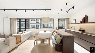 In het hart van het Zoute, discreet verscholen om de hoek van de Zeedijk en perfect gelegen tussen het Albertplein en het Driehoeksplein, bevindt zich dit volledig vernieuwde appartement met twee ruime slaapkamers. Een topligging waar licht, rust en zee samenkomen.<br /><br />Via de verzorgde inkomhal met vestiaire en gastentoilet betreedt u de royale leefruimte, die dankzij een uitzonderlijke gevelbreedte van maar liefst 7 meter baadt in het licht. De open, volledig uitgeruste keuken sluit hier naadloos op aan en is verfijnd afgewerkt met een travertin werkblad en hoogwaardige Miele-toestellen. Praktisch comfort is voorzien met een aansluiting voor wasmachine.<br /><br />De master bedroom straalt rust en elegantie uit, met maatwerk inbouwkasten en een privatief terras waar u een mooi zicht op zee geniet. Deze slaapkamer beschikt over een eigen badkamer. De tweede volwaardige slaapkamer is eveneens voorzien van ingemaakte kasten en heeft haar eigen douchekamer.<br /><br />Een private kelder en een gemeenschappelijke fietsenberging vervolledigen het geheel.<br /><br />Ook het gebouw zelf werd recent grondig vernieuwd: een nieuwe gevel, nieuwe terrassen met transparante balustrades, nieuwe ramen en een vernieuwde lift zorgen voor een hedendaagse uitstraling en extra wooncomfort. Gelegen op de vierde verdieping geniet het appartement het hele jaar door van een optimale zoninval.<br /><br />Een stijlvol en warm appartement, uitgevoerd in zachte zandtinten en duurzame materialen, op een steenworp van de Zeedijk van het Zoute.<br /><br />Optioneel: mogelijkheid tot aankoop van een garagebox in de Zoutelaan (Residentie Sun House – € 75.000).