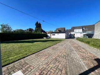 Ruime gezinswoning met 4 slaapkamers, garage, overdekte autostaanplaats en multifunctionele ruimte – ideaal voor gezinnen, hobbyisten of wie een bijberoep aan huis wil uitoefenen.<br />Deze goed ingedeelde halfopen bebouwing biedt heel wat ruimte en mogelijkheden. Dankzij de combinatie van een ruime woning, praktische bijruimtes, een grote tuin en een multifunctionele ruimte is dit een ideale thuis voor wie comfort en functionaliteit wil combineren.<br />Gelijkvloers<br />Via de inkomhal, voorzien van een gastentoilet, kom je in de aangename leefruimtes.<br />• Ruime woonkamer<br />• Aparte keuken<br />• Badkamer met aansluitend een apart toilet<br />Eerste verdieping<br />De verdieping beschikt over maar liefst 4 slaapkamers, waardoor deze woning perfect geschikt is voor een gezin of voor wie extra ruimte wenst voor een bureau, dressing of hobbykamer.<br />Extra ruimte<br />Via een plooitrap is de zolder bereikbaar. Daarnaast beschikt de woning over een ruime, droge kelder, ideaal als extra bergruimte.<br />Buiten<br />De woning beschikt over een ruime garage, overdekte autostaanplaats, multifunctionele ruimte en een grote tuin, waar volop ruimte is voor ontspanning.<br />Informatieverplichting: WG-VG-GMO-GVKR-GVV <br />P-score:A en G-score:A