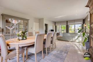 We vinden deze charmante villa met een karaktervolle uitstraling op een ruim perceel van 35a10ca, gelegen aan Russelt 106 in Wellen. De woning bevindt zich langs een vlotte verbindingsweg tussen het centrum van Alken en Wellen, met een snelle aansluiting op de expresweg richting Hasselt en Sint-Truiden. Openbaar vervoer, winkels, scholen en andere voorzieningen liggen in de directe omgeving.<br /><br />De villa werd gebouwd in 2000 met duurzame en kwalitatieve materialen en onderging in 2018 een grondige renovatie. Hierbij werden onder andere een nieuwe keuken en badkamer geplaatst, een bureauruimte op maat ingericht en de tuin volledig opgefrist. Daarnaast werden er twee poorten voorzien langs de servitudeweg en werd het perceel volledig omheind. In 2024 werd de woning verder geoptimaliseerd met de installatie van zonnepanelen (totaal vermogen 8.700 Wp) en een laadpaal.<br /><br />Met een bewoonbare oppervlakte van circa 380 m² en een perceel van 35a10ca staan ruimte, rust en privacy hier centraal. Bovendien beschikt de woning over een energiezuinig EPC-label B met een waarde van 160 kWh/m².<br /><br />Bij het betreden van de woning komt u in een ruime inkomhal met vestiaire en gastentoilet, die toegang biedt tot een stijlvolle bureauruimte op maat. In het interieur werd gekozen voor hoogwaardige en tijdloze materialen zoals massieve eik, travertin (perlato) en natuursteen, wat bijdraagt aan de warme en luxueuze uitstraling van de woning.<br /><br />De lichtrijke leefruimte met zit- en eethoek sluit naadloos aan op de op maat gemaakte keuken. Deze keuken is afgewerkt met een werkblad in Zimbabwe Black natuursteen en uitgerust met kwalitatieve toestellen, waaronder een Falcon inductiefornuis met salamander, hetelucht- en combioven, dampkap Novy, vaatwasser AEG en koelkast AEG.<br /><br />Vanuit zowel de leefruimte als de keuken geniet u van een prachtig zicht op de aangelegde tuin met fruitbomen en achterliggende weilanden. Aansluitend aan de keuken bevinden zich nog een praktische wasplaats met ingebouwde kasten, een aparte douchecel, een koel- en fietsenberging en twee standplaatsen met sectionale poorten, evenals de technische ruimte.<br /><br />Op de eerste verdieping geeft de ruime overloop toegang tot de master bedroom met dressing en een luxueuze badkamer, voorzien van ligbad, een inloopdouche in natuursteen en keramische panelen, dubbele wastafel en toilet. Daarnaast zijn er nog vier ruime slaapkamers en een tweede badkamer met douche, wastafel en apart toilet. Beide badkamers zijn bovendien uitgerust met vloerverwarming.<br /><br />De volledig geïsoleerde zolder, bereikbaar via een luik, biedt extra opslagmogelijkheden.<br /><br />De zuidoost georiënteerde tuin is een absolute troef: met een breedte van ongeveer 40 meter en een volledige omheining geniet u hier van optimale privacy en een open zicht op de achterliggende boomgaard en weilanden. Het (deels overdekte) terras met zonneluifel, de buitenbarbecue, de gezellige zithoek aan de vijver en het tuinhuis maken het geheel compleet.<br /><br />Troeven van de woning:<br />+ Ruim perceel van 35a10ca met een breedte van ca. 40 meter - straatbreedte 30 meter<br />+ Bewoonbare oppervlakte van ca. 380 m² (volgens EPC) - plafondhoogte inkomhal 3,08 m - plafondhoogte living/keuken 2,62 m<br />+ Karaktervolle en tijdloze architectuur<br />+ Luxueuze afwerking met hoogwaardige materialen (massieve eik, travertin, natuursteen)<br />+ Volledig instapklaar dankzij renovatie<br />+ Zeer praktische woonindeling met veel licht<br />+ Energiezuinig (EPC-label B – 160 kWh/m²)<br />+ Zonnepanelen en laadpaal aanwezig<br />+ 5 volwaardige, ruime slaapkamers<br />+ Rustige, groene omgeving met open zicht<br />+ Volledige privacy in de tuin<br /><br />Kortom, deze landelijke villa combineert ruimte, comfort en hoogwaardige afwerking met een uitzonderlijk gevoel van rust en privacy — een ideale thuisbasis voor wie op zoek is naar stijlvol wonen.<br /><br />Wenst u meer informatie of een bezoek ter plaatse? Neem gerust contact op met Stephanie Odeurs via 0474 73 64 84 of via e-mail: stephanie@vestio.com.