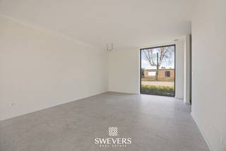 In een rustige woonwijk in het groene Leopoldsburg ontdek je deze stijlvolle halfopen nieuwbouwwoning, gebouwd in 2025. Met een moderne uitstraling, functionele indeling en energiezuinige aanpak vormt deze woning de perfecte match voor gezinnen, koppels of wie gewoon op zoek is naar hedendaags wooncomfort. Hier woon je in alle rust, maar toch vlak bij alles wat je nodig hebt.<br /><br />De woning heeft een bewoonbare oppervlakte van 158,40 m² en is gespreid over twee volwaardige bouwlagen. Dankzij het doordachte ontwerp voelt elke ruimte open en licht aan. De woning werd recent opgeleverd en is volledig instapklaar. Dit betekent: geen renovatiewerken, geen zorgen — gewoon verhuizen en genieten.<br />Op de gelijkvloerse verdieping bevindt zich een ruime inkomhal met vestiairemogelijkheid en gastentoilet. Van daaruit wandel je zo door naar de leefruimte van 44 m², die dankzij haar open karakter bijzonder uitnodigend aanvoelt. <br /><br />De grote glaspartijen zorgen niet alleen voor een overvloed aan daglicht, maar geven ook directe toegang tot het terras en de zuidoostelijk georiënteerde tuin. Achteraan is er voldoende ruimte voor kinderen om te spelen of om in alle rust te genieten van een zonnige ochtendkoffie. De aangrenzende keuken van 18 m² biedt plaats voor een gezellige ontbijthoek en is praktisch ingericht met zicht op de tuin. Aansluitend is er nog een inpandige berging van 3,84 m², ideaal voor voorraad of wasmachine.<br /><br />Boven zijn drie slaapkamers voorzien, telkens met voldoende lichtinval en ruimte voor kasten en bureau. De master bedroom meet 14 m² en is perfect voor een groot tweepersoonsbed en extra opbergruimte. De andere twee slaapkamers (beide 11 m²) zijn ideaal als kinderkamer, logeerkamer of thuiskantoor. De kamers bevinden zich rond een centrale nachthal, die ook toegang geeft tot een comfortabele badkamer. Deze is 7,03 m² groot en voorzien van een dubbele lavabo, toilet, ligbad en aparte douche — alles wat je nodig hebt om de dag ontspannen te starten. <br />Extra opbergruimte is voorzien in een tweede berging van 5,44 m², handig voor was- en strijkmateriaal of als seizoensopslag.<br /><br />Dankzij de afwezigheid van een kelder of zolder worden alle functionele ruimtes benut op de twee bestaande woonlagen. Dit zorgt voor een overzichtelijke woning zonder verloren vierkante meters.<br /><br />Met een perceel van 321 m² geniet je van een tuin op mensenmaat. De oriëntatie naar het zuidoosten garandeert zon van 's ochtends tot in de vroege namiddag. De perfecte plek om een terras aan te leggen, een speelplek voor de kinderen te creëren of een rustige hoek in te richten om te ontspannen met een boek. Een carport naast de woning biedt ruimte voor een wagen, met extra plaats voor fietsen of tuinmateriaal.<br /><br />Naast de functionele indeling en het moderne wooncomfort is het vooral de ligging die deze woning extra aantrekkelijk maakt. Op slechts 200 meter bevinden zich scholen, ideaal voor jonge gezinnen. Het station ligt op amper 650 meter, wat zorgt voor een vlotte verbinding richting onder andere Hasselt of Antwerpen. Restaurants, winkels en sportinfrastructuur zijn bereikbaar op minder dan een kilometer. En de snelweg? Die bereik je binnen de tien minuten.<br /><br />Bovendien biedt deze woning een voordelig fiscaal voordeel: de grondwaarde bedraagt € 90 000 (12% registratierechten), terwijl de constructiewaarde van € 294 500 onder het 6 % btw-tarief valt.<br /><br />Deze woning combineert hedendaags wooncomfort met een slimme indeling, gunstige ligging en een zonnige tuin. Volledig nieuw, perfect afgewerkt en klaar voor de toekomst. Wil je het zelf ervaren? Bel ons vandaag nog voor een afspraak op 011 255 155 en ontdek de mogelijkheden tijdens een persoonlijke rondleiding. Bron bewoonbare oppervlakte: EPC – verslag.