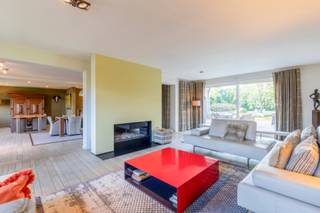 Deze ruime en instapklare woning van 705 m² bevindt zich in een residentiële buurt op enkele minuten van het centrum van Assenede. Door de nabijheid van de R4 en de E34 is de directe verbinding richting Knokke, Antwerpen en Gent een troef. <br /><br />Op het sierlijke perceel van 6.418 m² geniet u van optimale privacy, een zonnige tuin met zuidwestelijke oriëntatie en een aangenaam wooncomfort. De woning bestaat uit royale ruimtes en is doorheen de jaren kwalitatief ingericht. <br /><br />Bij het binnenkomen wordt u verwelkomd in een ruime inkomhal met gastentoilet die rechtstreekse toegang biedt naar een bureauruimte, een wasruimte die ook kan dienen als tweede keuken en een praktijkruimte of slaapkamer. Daarnaast bevindt er zich op het gelijkvloers ook nog een lichtrijke leefruimte met houthaard en idyllische veranda, een hyper-geïnstalleerde keuken, een berging en een dubbele inpandige garage. <br /><br />Via twee vaste trappen komt u op de eerste verdieping waar er zich vijf ruime slaapkamers met ingebouwde kasten, twee ruime badkamers, een dressing en een apart toilet bevindt. De grootste badkamer is tevens uitgerust met een ligbad met bubbels, douche, sauna en dubbele lavabo. De zolderverdieping biedt extra opslagruimte en de wijnkelder extra plezier. <br /><br />De volledig aangelegde siertuin beschikt over een groot terras, een mooie visvijver en een grote natuurlijke vijver achteraan het perceel. Verder is er een recente serre en een aparte garage die ook dienst kan doen als tuinberging. Op de oprit is er parkeergelegenheid voor meerdere wagens. <br /><br />De woning biedt tal van mogelijkheden zoals wonen, al dan niet in combinatie met een zelfstandig beroep of co-housing. Er is ook een optie om een tweede oprit aan te leggen. <br /><br />EPC B / CV op stookolie / EK: niet conform / asbestveilig (maar niet asbestvrij) <br /><br />Benieuwd naar deze ruime woning op riant perceel met siertuin? Maak een vrijblijvende afspraak via michiel@landbergh.be of 09 278 78 79. 