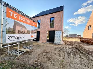 <strong>Welkom in Hoeilaart Bemdekensveld!</strong><br /><br />In Hoeilaart bouwt Matexi 7 ruime nieuwbouwwoningen. Samen vormen ze een kleinschalige buurt die ideaal gelegen is, vlakbij het centrum van Hoeilaart op slechts enkele minuten van Brussel.<br /><br />Dé grote troef van Bemdekensveld is de strategische locatie. Je bevindt je hier vlakbij het centrum van Hoeilaart en <strong>je bereikt snel de snelweg</strong>. Het <strong>Zoniënwoud ligt op maar 5 minuutjes</strong> <strong>fietsen</strong>, het station op 10 minuten.<br /><br />Ook de omgeving maakt dit kleinschalige project ontzettend aantrekkelijk voor gezinnen.<br /><br />De woningen zelf zijn ruim, <strong>comfortabel en energiezuinig</strong>. Dankzij <strong>zonnepanelen en warmtepomp</strong> wordt je energiefactuur tot een minimum herleid. Het hedendaagse ontwerp gaat hand in hand met een kwalitatieve afwerking.<br /><br />Lot 1 is een <strong>halfopen bebouwing</strong> met <strong>4 slaapkamers </strong>met een <strong>grondoppervlakte </strong>van <strong>388 m²</strong>. De <strong>inpandige garage</strong> en de aanleg van het terras zitten mee inbegrepen in de prijs, de <strong>zolder is optioneel af te werken</strong>.<br /><br />Heb je interesse? Neem dan snel contact met ons op.