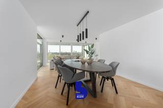 Exclusief en Luxueus Appartement nabij het Strand – Mariakerke, Oostende<br /><br />Voor wie verlangt naar een verfijnde en luxueuze leefomgeving, biedt dit exclusieve appartement nabij het strand van Mariakerke een ongeëvenaarde ervaring. Dit ruime en stijlvol gerenoveerde verblijf (2024) is gevestigd in een recent gebouw en is volledig instapklaar, met een energielabel B dat zorg draagt voor een energiezuinig verblijf.<br /><br />Indeling &amp; Kenmerken:<br />Met een royale oppervlakte van 162 m² geniet u van een indeling die functionaliteit en elegantie combineert. Bij binnenkomst komt u in een statige inkomhal die leidt naar een indrukwekkende, lichtrijke woonkamer met een prachtig visgraatparket die de ruimte grandeur geeft. De open keuken is voorzien van hoogwaardige, geïntegreerde apparatuur (gaggenau) en biedt een overvloed aan kastruimte – ideaal voor culinaire fijnproevers.<br /><br />Dit appartement omvat drie ruime slaapkamers, waaronder een verfijnde master suite met een en-suite badkamer voorzien van een luxueus ligbad en een stijlvol dubbel lavabomeubel. Voor uw comfort is er een tweede badkamer met een wellnessdouche uitgerust met geavanceerde functies zoals stoom, muziek, aroma, en massagejets. Verder biedt het appartement een praktische berging met aansluiting voor wasmachine en een apart toilet.<br /><br />Buitenzijde:<br />Het indrukwekkende terras van maar liefst 66 m² omringt het appartement en biedt adembenemende uitzichten op de zee en de wellington golfbaan van Oostende. Een plek om volledig tot rust te komen terwijl u geniet van de serene omgeving.<br /><br />Extra Faciliteiten:<br />Het gebouw is voorzien van een beveiligde fietsenberging, en er bestaat de mogelijkheid om een garagebox aan te kopen, wat extra comfort en gemak toevoegt.<br /><br />Ligging:<br />Dit exclusieve appartement bevindt zich in Mariakerke, een rustige en prestigieuze wijk in Oostende. Geniet van de nabijheid van het strand, de Wellington Golf, het zwembad en tal van winkels, supermarkten, en openbaar vervoer. De ligging is ideaal voor wie de balans zoekt tussen ontspanning en stadscomfort.
