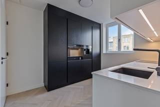Deze gloednieuwe penthouse (4de verdiep) combineert verfijnde luxe met een unieke ligging in een stijlvol gebouw met een karaktervolle modernistische gevel, op amper enkele stappen van het strand en de winkelstraat. De lift brengt u rechtstreeks tot in het appartement, wat garant staat voor comfort en discretie.<br /><br />Indeling: lichtrijke leefruimte met toegang tot privatief zonneterras. De aparte keuken is uitgerust met kwalitatieve toestellen. Verder is er een handige berging voorzien. De eerste slaapkamer van 16 m² heeft een eigen badkamer met ligbad, wastafelmeubel en toilet. De tweede, grotere slaapkamer (19 m²) beschikt over een privé douchekamer met inloopdouche, dubbel wastafelmeubel en toilet. Daarnaast is er ook een apart gastentoilet.<br /><br />Het appartement is afgewerkt met hoogwaardige materialen en moderne comfortvoorzieningen.<br /><br />Er is tevens een privékelder inbegrepen. In het gebouw bevinden zich bovendien een ruime fietsenberging met verschillende oplaadpunten én een gemeenschappelijk dakterras dat de hele dag zon biedt.<br /><br />!!!!Verkoop valt onder registratierechten (geen BTW van toepassing).