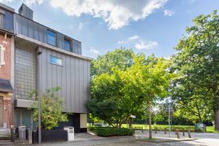 <p><strong>In de gegeerde Pulhofwijk te Berchem, aan het Nachtegalenpark, vindt u deze ruime en lichtrijke halfopen architectenwoning met zonnig georiënteerde tuin.</strong></p>
<p>De veelzijdige indeling leent zich zowel voor een comfortabel gezinshuis als voor een combinatie van wonen en werken. Ook co-housing of kangoeroewonen behoort tot de mogelijkheden: samenleven onder één dak, met ruimte voor ieders privacy. Met tot vijf mogelijke slaapkamers en drie badkamers biedt deze woning de flexibiliteit om mee te groeien met uw gezin en woonwensen.</p>
<p>De lichtrijke inkomhal verwelkomt u en geeft rechtstreeks toegang tot de inpandige garage. Een niveau lager bevinden zich een eerste ruimte die ook als kantoor kan worden ingericht en een extra kantoor- of slaapkamer met een eigen badkamer, uitgerust met douche, wastafel en toilet. Een fijne plek om rustig te werken of gasten te ontvangen.</p>
<p>De zitruimte sluit aan op de lichtrijke eetkamer en de halfopen, volledig ingerichte keuken voorzien van opbergkasten en toestellen; een oven, kookplaat, dampkap en vaatwasser. Airconditioning zorgt hier voor extra comfort. De glazen deur geeft u toegang tot het terras met elektrische zonnewering en de aangelegde tuin. Een uitnodigende plek om buiten te eten of de dag ontspannen af te sluiten.</p>
<p>De verdieping biedt plaats aan de masterbedroom, een tweede slaapkamer en een ruime wasruimte die ook een andere invulling kan krijgen. De badkamer beschikt over een dubbele wastafel, een bad en een inloopdouche. Het toilet bevindt zich apart.</p>
<p>Ook bovenaan verrast deze woning. De hoogste verdieping is ingericht als studioverdieping, met een ruime leefruimte, een comfortabele open keuken en een eigen badkamer met wastafel, toilet en inloopdouche. Via een trap bereikt u de bijbehorende duplex-slaapkamer op de zolderverdieping. Deze opzet biedt extra mogelijkheden voor wie onder één dak wil samenleven en tegelijk ruimte voor privacy zoekt.</p>
<p>De inpandige garage en oprit maken de woning compleet.</p>
<p>Met een gunstig EPC, een asbestveilig attest en een conforme elektrische installatie beschikt deze woning bovendien over belangrijke troeven.</p>
<br /><span><strong>BIJZONDERHEDEN:</strong></span><br />* Zeer ruime en polyvalente archtecturale Halfopen bebouwing op absolute toplocatie in de gegeerde Pulhofwijk. <br />* Tot 5 slaapkamers mogelijk en 3 badkamers.<br />* Ruime inpandige garage met oprit <br />* Gunstige EPC, Asbestveilig en Electriciteit conform.