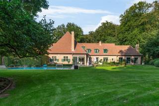 <p><span>Deze klassieke villa is gelegen op een AAA-locatie aan de Bellevuedreef te Schilde, nabij het park.</span></p><p><span>De omheinde tuin van ca. 1,4 Hectare biedt u alle rust en privacy. </span></p><p><span> </span></p><p><span>Indeling</span></p><p><span>U betreedt de villa middels de centrale inkomhal met vestiaire en gastentoilet alsook de trap naar de verdieping. Vanuit de inkomhal toegang tot de ruime leefruimte bestaande uit een zitkamer, een eetkamergedeelte met aansluitend een studeerkamer alsook vanuit de eetkamer toegang tot de ruime leefkeuken. Tevens vanuit de inkomhal toegang tot een ruim bureel met prachtige ingemaakte kasten. De leefkeuken bestaat uit een ontbijtkamer met grote schuiframen naar tuin en terras en een werkgedeelte met eiland en is voorzien van diverse inbouwtoestellen waaronder een Amerikaanse ijskast, combioven en stoomoven, etc. Vanuit de keuken een tweede doorgang naar de eetkamer via een berging en doorgang naar de bijkeuken met zij-inkom. </span></p><p><span> </span></p><p><span>Verdieping</span></p><p><span>De nachthal geeft toegang tot een ruime slaapkamer met eigen badkamer, een logeerkamer met eveneens een eigen badkamer, derde ruime kinderkamer met opnieuw een eigen badkamer. De mastersuite omvat een ruime slaapkamer, dressingkamer en een luxe badkamer. Vanuit de mastersuite doorgang naar de tussengang en diensttrap naar conciërgegedeelte. </span></p><p><span> </span></p><p><span>Garage</span></p><p><span>Inpandige garage voor drie wagens voorzien van automatische poorten. </span></p><p><span> </span></p><p><span>Conciërgewoning</span></p><p><span>Boven de garage bevindt zich een conciërgewoning welke bestaat uit een polyvalente ruimte, slaapkamer en badkamer. </span></p><p><span> </span></p><p><span>Kelder</span></p><p><span>U bereikt de kelder middels een draaiende trap uit natuursteen, de kelder biedt bergruimte, technische ruimte voor CV en zwembad alsook een fraaie wijnkelder. </span></p><p><span> </span></p><p><span>Poolhouse</span></p><p><span>Het grote bijgebouw werd gebouwd in dezelfde materialen als de villa en biedt een volwaardig gastenverblijf met woonkamer, keuken, slaapkamer en badkamer. </span></p><p><span> </span></p><p><span>Bijzonderheden </span></p><p><span>De villa werd gebouwd in 1978 en in 1996 vond een uitgebreide renovatie plaats met vervolgens regelmatige onderhouds- en opfrissingswerken. Er is een verwarmd zwembad aanwezig, ruime terrassen, aangelegde en omheinde tuin met tuinverlichting. De woning is zeer goed beveiligd en voorzien van alarm, camerabewaking etc.</span></p><p><span> </span></p><p><span>Meer inlichtingen via ons kantoor.</span></p>
