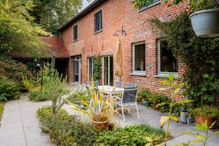 In het hart van het groene Pajottenland, in het rustige Herne, bevindt zich deze karaktervolle woning met een rijke invulling als B&amp;B. De ligging in de Breemstraat biedt een perfecte balans tussen landelijke rust en bereikbaarheid. Op wandelafstand ligt het treinstation van Herne. De omliggende natuur nodigt uit tot wandelen en fietsen, terwijl steden zoals Edingen, Geraardsbergen vlot bereikbaar zijn.<br /><br />Bij het binnenkomen van de woning word je verwelkomd in een ruime inkomhal met gastentoilet en vestiairekast. Vanuit hier heb je toegang tot een slaapkamer met ensuite badkamer, de leefruimte en de keuken. De keuken sluit aan op een praktische wasplaats, vanwaar je ook toegang hebt tot de kelder. De leefruimte loopt door in een gezellige eetplaats, die momenteel dienstdoet als ontbijtruimte voor gasten. Deze ruimte is voorzien van een bar en een zithoek, en vormt het sociale hart van de woning.<br /><br />Vanuit deze gastenzone leidt een trap naar het gastenverblijf op de eerste verdieping. Hier bevinden zich vier comfortabele kamers, elk met een eigen ensuite badkamer. Op de tweede verdieping zijn er nog twee kamers, een aparte badkamer en een ruime polyvalente kamer die tal van mogelijkheden biedt, van extra slaapkamer tot hobbyruimte of bureau.<br /><br />De woning beschikt bovendien over een ruime tuin, ideaal voor ontspanning of het ontvangen van gasten.