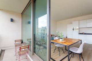 Wonen in alle rust, maar toch vlak bij alles wat de stad te bieden heeft? Dan is dit appartement, met een ligging tussen het historische centrum en het Eilandje, precies wat je zoekt. Het gebouw werd opgeleverd in 2016 en ontleent zijn naam aan de bronzen munten die ooit op deze plek werden teruggevonden. Een knipoog naar het rijke Antwerpse verleden. Het appartement op de derde verdieping voelt licht en ruim dankzij de hoge plafonds en grote ramen. De leefruimte en open keuken vloeien harmonieus in elkaar over en geven uit op het zonnige terras met zicht op het verzorgde groene binnenplein. Met twee volwaardige slaapkamers, een moderne badkamer en een aparte berging biedt dit appartement alle comfort voor eigentijds stadswonen. De poort naar het binnenplein wordt vanaf de avond gesloten voor dat extra veilg gevoel. Kortom: comfortabel en eigentijds wonen in een recente, rustige setting, op wandelafstand van alles wat Antwerpen te bieden heeft. Meer info? Walls.be - Epc: 100,27 kWh/m2 – E64, P-score: C, G-score :C, Stedenbouwkundige informatie in aanvraag