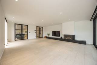 <p><span>Aan het einde van de rustige, doodlopende Pruimelaarstraat, ligt deze luxueus afgewerkte woning (2019) met een verzorgd aangelegde tuin, camera’s, alu antraciet buitenschrijnwerk (Reynaers), wachtleiding voor oplaadpunt, alu poort, geïntegreerde pakketbrievenbus, maatkasten, etc. De gelijkvloerse verdieping is voorzien van hoogwaardige designbinnendeuren van Anyway Doors. De EPC-score van 89 (Label A) werd bereikt door integratie van: algemene vloerverwarming, condensatieketel, 18 zonnepanelen en dikke isolatielagen. De ruime leefruimte beschikt over een tv-meubel (maatwerk), geïntegreerde gashaard (M-Design), afstandsbediende elektrische binnenlamellen (Somfy), ingebouwde speakers, grote alu schuiframen (Reynaers), gepolierde betonvloer en plafondhoge deuren (Nordex). Let in de aangelegde tuin met veel privacy op de prijzige overdekte terrasconstructie (Brustor), de robotmaaier, het bijgebouw en de tuinverlichting (app). In de luxueuze keuken (Grando), spotten we veel (verborgen) bergruimte, Dekton werkbladen, een groot kookeiland (6 zitplaatsen), Miele toestellen (oven, microgolfoven, koffiemachine, koelkast, diepvries), plus een kookplaat met geïntegreerde afzuiging. Opbergruimte is beschikbaar in een wasplaats, een droge kelder en een technische ruimte. In de toiletten is zelfs de rolhouder geïntegreerd in de muur. De luxe-badkamer is groot genoeg voor de inloopdouche (stalen deur) en het dubbele badkamermeubel (maatwerk). Alle kamers bieden plaats voor een dubbel bed. De exclusieve handgemaakte trap van Genico met Corian afwerking en geïntegreerde LED-verlichting, geeft aan van welk hoog niveau de afwerking wel is.</span></p>