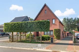 Voor meer info en foto’s, surf naar www.swevers.be – Op een ruim perceel van 865 m² in Heusden-Zolder bevindt zich deze open bebouwing met 182 m² bewoonbare oppervlakte. De woning uit 1954 biedt veel ruimte, een praktische indeling en een groene omgeving. Op het gelijkvloers vindt u een inkomhal, apart toilet, een royale woonkamer van 40,30 m² en een ruime keuken van 20,61 m² met aansluitende berging. Verder zijn er een badkamer en een ruime veranda met zicht op het achterliggende groen. De eerste verdieping telt drie slaapkamers van 20,80 m², 12,82 m² en 9,56 m². Daarnaast beschikt de woning over een kelder van 7,62 m² en een grote zolder, ideaal voor extra opslag. Het zuidwestelijk georiënteerde perceel biedt volop mogelijkheden om van de tuin te genieten. De zwemvijver en het bos achter de woning versterken het groene karakter. Een vrijstaande garage van 46 m² biedt plaats aan twee wagens en beschikt eveneens over een kelder. De kraan in de garage is aangesloten op een grondwaterput. Zonnepanelen en een batterij zijn eveneens aanwezig. Ook de ligging is praktisch, met openbaar vervoer op ca. 190 meter en winkels en restaurants op ongeveer 1 km. Scholen en ontspanningsmogelijkheden bevinden zich eveneens vlot bereikbaar. Voor meer informatie, bel 011 255 155. Bron bewoonbare oppervlakte: EPC – verslag.