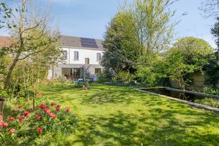 Bent u op zoek naar een lichtrijke, ruime en charmante woning? Dit herenhuis in het hart van Assenede combineert authenticiteit met hedendaags comfort en energiezuinigheid, met maar liefst 345 m² bewoonbare oppervlakte.U betreedt de woning via een royale inkomhal. Aan de ene zijde bevindt zich een ruimte ideaal als bureel of praktijk, aan de andere een tweede bureau met directe verbinding naar de leefruimte. Deze omvat een gezellige zithoek met houtkachel, open keuken en lichtrijke eetplaats met zicht op de tuin. Verder zijn er een berging, toilet en kelder.Op de eerste verdieping vindt u vier ruime slaapkamers en een badkamer met douche, toilet en wastafel. Authentieke houten vloeren zorgen voor extra charme.De open zolder met mezzanine biedt tal van mogelijkheden.Buiten geniet u van een zuidwestgerichte tuin met terras, vijver, serre, bergruimte, parkeerplaats en achteruitgang. Fruitbomen en twee prachtige magnolia’s maken het geheel compleet. Vooraan geniet u van open zicht op het park.Kortom: een unieke woning vol ruimte en karakter.Gepubliceerde prijs is een instelprijs.De algemene voorwaarden van Dewaele DIY kunt u steeds raadplegen via dewaele.com.Bestuursmaatregelen in het maatregelenregister: nee