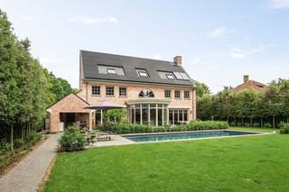 <p><span>Exclusieve villa met hoogwaardige afwerking op een rustige en residentiële ligging te Grobbendonk. </span></p><p><span> </span></p><p><span>Indeling</span></p><p><span>U betreedt de villa middels de centrale inkomhal met prachtige eiken trap naar de verdieping en een gastentoilet. Vanuit deze entreehal toegang naar garage, kelder, keuken en koele berging middels een dienstgang. Via een dubbele deur bereikt u de leefruimte met de centrale eetkamer en grote orangerie met vide als middelpunt van de woning. Ruime woonkamer met prachtige open haard en openslaande deuren naar tuin en terras. Tevens toegang vanuit de centrale eetkamer naar de luxe afgewerkte leefkeuken met eveneens toegang tot tuin en terras alsook een overdekt terras. Daarnaast beschikt de villa over een ruime bijkeuken/wasplaats en vestiairekamer alsook de eerder genoemde koele berging.</span></p><p><span> </span></p><p><span>Garage</span></p><p><span>De inpandige garage is zeer ruim en biedt eenvoudig ruimte aan twee wagens en bijkomende bergruimte. De garage is voorzien van automatische poorten. </span></p><p><span><br />Kelder</span></p><p><span>De villa is gedeeltelijk onderkelderd met bergruimte en technische ruimte alsook een mogelijke wijnkelder. </span></p><p><span> </span></p><p><span>1e Verdieping</span></p><p><span>Middels de statige trap bereikt u de eveneens indrukwekkende nachthal met gastentoilet. Vanuit deze nachthal heeft u toegang tot een ruime mastersuite bestaande uit een royale slaapkamer met prachtig zicht op de tuin, een ingerichte dressingkamer en een ruime luxe afgewerkte badkamer. Nog twee zeer ruime slaapkamers en een tweede badkamer. </span></p><p><span> </span></p><p><span>2e Verdieping</span></p><p><span>Middels een vaste trap bereikt u een grote polyvalente ruimte welke deels is afgewerkt en reeds werd voorzien van ingemaakte bergkasten. Deze tweede verdieping bestaat uit een grote open ruimte alsook een tweede grote kamer welke kan worden ingericht als gastenkamer of ruimte voor inwonend personeel. </span></p><p><span> </span></p><p><span>Tuin en buitenruimtes</span></p><p><span>De ruime tuin biedt u veel rust en privacy alsook een zeer gunstige zonligging. Aan de achterzijde van de woning bevinden zich meerdere terrassen waaronder een overdekt terras. Er is een prachtig zwembad aangelegd welke is verwarmd en voorzien van een automatisch rolluik. Achteraan op het perceel is reeds een poolhouse aanwezig en zijn mogelijkheden tot het uitbreiden van dit poolhouse tot een polyvalent bijgebouw. </span></p><p><span> </span></p><p><span>Bijzonderheden</span></p><p><span>Deze villa werd gebouwd in 2001 en werd zeer recent volledig gerenoveerd en afgewerkt op een zeer hoog niveau. De woning is uitgerust met domotica, zonnepanelen, opnieuw aangelegde tuin met verlichting, beregening etc. Zowel op technisch als esthetisch gebied werden steeds de beste materialen gekozen. De ruime tweede verdieping biedt u mogelijkheden voor bijkomende slaapkamers of hobbyruimte. Het poolhouse biedt u ook diverse mogelijkheden. CV installatie met warmtepomp, EPC label A!</span></p><p><span>Enkel een bezoek ter plaatse kan u de kwaliteit van dit eigendom laten ervaren. </span></p><p><span>Meer informatie via ons kantoor.</span></p><p><span> </span></p>