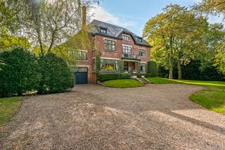 Unieke en karaktervolle eigendom met maar liefst 679 m² bewoonbare oppervlakte op een indrukwekkend perceel van 3.729 m², centraal gelegen in Mol-Wezel.<br /><br />Deze sfeervolle woning met geschiedenis combineert statige architectuur, royale leefruimtes en wooncomfort met een uitzonderlijk gevoel van ruimte en privacy. De woning wordt volledig omringd door een fraai aangelegde parktuin met buitenzwembad, zuidelijk terras en twee vrijstaande bijgebouwen.<br /><br />Met maar liefst 8 slaapkamers, 2 ingerichte badkamers, een extra douchekamer, meerdere leefruimtes, een inpandige garage en ruime zolderverdiepingen biedt deze eigendom een bijzonder veelzijdige woonbeleving. Dankzij de royale oppervlaktes en de vele afzonderlijke ruimtes is de woning bovendien uitermate geschikt voor een groot gezin of voor wie wonen en werken wenst te combineren. <br /><br />Gelijkvloers<br />Via de statige inkomhal betreedt u de woning. De inkomhal beschikt over een vestiaire en gastentoilet en vormt het centrale vertrekpunt naar de verschillende leefruimtes. De centrale houten trap die loopt tot de tweede verdieping biedt bijzondere zichten.<br /><br />De woning beschikt over een ruime en sfeervolle leefruimte. Grote raampartijen zorgen voor een aangename verbinding met de omliggende tuin en brengen het groen letterlijk naar binnen.<br /><br />Daarnaast bevindt zich een aparte eetkamer, ideaal voor gezellige familiemomenten en uitgebreid tafelen.<br /><br />De ingerichte keuken met ontbijthoek vormt een praktische en aangename leefkeuken en sluit mooi aan bij de overige leefruimtes.<br /><br />Het gelijkvloers wordt vervolledigd door een inpandige garage en een extra toilet aan de zij-ingang, bijzonder praktisch voor dagelijks gebruik en bij het betreden van de woning vanuit de tuin. <br /><br />De woning is volledig onderkelderd, bereikbaar vanuit de dienstingang en de garage.<br /><br />Vanuit de zijingang is er een tweede diensttrap die via de tussenverdieping loopt tot de eerste verdieping.<br /><br />Tussenverdieping<br />Een tussenverdieping biedt bijkomende praktische ruimte met een kamergrote wasplaats en een douchekamer met toilet.<br /><br />Deze verdieping vormt een handige overgang naar het ruime slaapgedeelte van de woning.<br /><br />Eerste verdieping<br />Op de eerste verdieping bevinden zich 4 bijzonder ruime slaapkamers en een ingerichte badkamer.<br /><br />De royale kamers bieden volop mogelijkheden voor slaapkamers, dressing, bureau of hobbyruimte. De hoge plafonds en authentieke elementen versterken het karaktervolle gevoel dat deze woning typeert.<br /><br />Tweede verdieping<br />De tweede verdieping verrast opnieuw door haar uitzonderlijke ruimte en veelzijdigheid.<br /><br />Hier bevinden zich nog eens 4 slaapkamers, een ingerichte badkamer, een praktische opbergruimte en bovendien 2 ruime zolderruimten.<br /><br />Deze verdieping leent zich uitstekend voor een groot gezin, maar biedt eveneens tal van mogelijkheden voor een thuiskantoor, hobbyruimte, speelruimte of extra bergruimte.<br /><br />Een tuin als verlengstuk van de woning<br />Een van de absolute troeven van deze eigendom is het uitzonderlijke perceel van 3.729 m².<br />De woning wordt volledig omgeven door een goed onderhouden aangelegde parktuin, waardoor u rondom geniet van groen, rust en privacy. Het buitenzwembad vormt samen met het terras een heerlijke plek om tijdens de zomermaanden te ontspannen en gasten te ontvangen.<br /><br />De combinatie van de royale tuin, het zwembad en de authentieke architectuur zorgt voor een unieke sfeer en een bijzonder residentieel karakter.<br /><br />Daarnaast beschikt de eigendom over 2 vrijstaande bijgebouwen, die heel wat extra mogelijkheden bieden voor opslag, hobby's, een atelier of andere doeleinden.<br /><br />Een uitzonderlijke eigendom voor wie op zoek is naar ruimte, karakter en privacy, gecombineerd met een royale tuin en zwembad, en dit op een centrale locatie in Mol-Wezel.<br /><br />Bijzonderheden<br />•Authentieke en karaktervolle ingenieurswoning<br />•Fraai aangelegde parktuin rondom de woning<br />•Privé-buitenzwembad<br />•Ruime kelder aanwezig<br />•Zuidgericht terras<br />•Verwarming op aardgas (nieuw sinds 2026)<br />•Perceel is achteraan toegankelijk <br />•Eigendom opgenomen in de Vlaamse Inventaris van het Onroerend Erfgoed (straat St. Jozefslaan)<br />•EPC: 290 kWh/m² – energielabel C