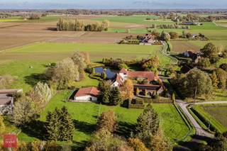 Gelegen op de grens met Wannegem-Lede, prachtig gerestaureerde vierkantshoeve op ca. 1,3ha bestaande uit inkomhal, living met open ingerichte...