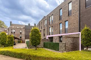 Centraal gelegen op het Begijnhofplein in Halen vinden we dit gelijkvloers appartement. Residentie ‘De Rivieren’ werd gebouwd in 2012 en bestaat in totaal uit 28 appartementen. Nummer 1, waar het appartement gelegen is, telt 7 app. De gelijkvloerse verdieping telt 2 app.

We komen binnen in de inkomhal, met een apart toilet, en ruimte voor een vestiairekast. Via de glazen deur komen we in de ruime woonkamer (34 m²), van waaruit we toegang hebben tot het terras vooraan (8 m²). Naastliggend vinden we de open keuken (8 m²), die voorzien is van kookplaat, afwasmachine, oven, koelkast en wasbak. In de berging (5 m²) vinden we de aansluiting voor het wasmachine.

Het appartement telt twee grote slaapkamers (13 en 11 m²). Via de slaapkamers hebben we toegang tot het zeer ruime terras (42 m²) aan de achterzijde. De badkamer (9 m²) is uitgerust met ligbad, douche en badkamermeubel met lavabo. 

Bij het appartement hoort tevens een ondergrondse autostaanplaats en een handige kelderberging (5 m²), die te bereiken is via de lift of de trap. Ook vinden we hier een gemeenschappelijke fietsenberging. De kelderverdieping is uitgerust met camerabewaking.

Het appartement wordt verwarmd op aardgas en heeft ramen met dubbel glas (aluminium-profielen). De ramen van de slaapkamers zijn uitgerust met rolluiken. Hierdoor heeft het appartement een gunstig EPC met label B (110 kWh/m² jaar). De elektriciteit is conform het AREI. 

Er is een syndicus en de vaste kosten bedragen 91 euro per maand. 