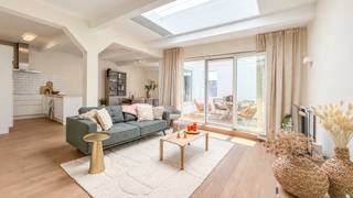 This modern and exceptionally bright apartment of approximately 120 m² is located on the third floor of the “South Eden” residence, ideally situated between Kasteelpleinstraat and Mechelseplein, on the edge of Antwerp’s Zuid district and the equally trendy Theatre Quarter.
The façade tells a story. Originally built in 1899 as a warehouse and shop specialising in tableware, including porcelain, faience, crystal and silverware, the building underwent a complete renovation and conversion into apartments in 2013.
Upon entering, the central dome immediately creates a wonderful sense of light and space. The distinctive layout separates the living room from the dining area. The approximately 11 m² enclosed terrace feels like a private patio, offering pleasant privacy.
The kitchen is equipped with a fridge-freezer, dishwasher, induction hob and combination microwave oven. The metro-style tiles add extra character.
The bedrooms are situated at the quiet rear of the building. The spacious master bedroom features fitted wardrobe space. The second bedroom is ideal as a child’s or guest room, or as a home office.
The contemporary bathroom features a generous walk-in rain shower, a vanity unit with washbasin and a toilet. Connections for a washing machine and tumble dryer are provided.
A private cellar provides additional storage space.
A parking space can be purchased separately for €35,000, excluding registration tax.