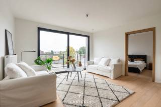 Wonen met comfort in het groen van Kluisbergen. Dit mooi afgewerkte nieuwbouwappartement van ca. 69m² (incl. terras) combineert eigentijdse architectuur met een kwalitatieve afwerking en unieke extra faciliteiten.<br /><br />Het appartement<br />Bij het binnentreden valt direct de warme sfeer op dankzij de prachtige parketvloer die is doorgetrokken in de leefruimte. De lichtrijke woonkamer staat in een open verbinding met de moderne, volledig geïnstalleerde keuken die is uitgerust met alle nodige comfort. Het appartement beschikt over één volwaardige, rustige slaapkamer, een strak afgewerkte badkamer met een comfortabele douche en een handige aparte berging. Buiten geniet u in alle rust op uw eigen privatieve terras.<br /><br />Unieke gemeenschappelijke faciliteiten<br />Wat dit gebouw extra aantrekkelijk maakt, zijn de uitstekende voorzieningen voor de bewoners. U krijgt toegang tot een mooi aangelegde gemeenschappelijke tuin met een petanquebaan, een gezellige ontmoetingszaal en een ruime veilige fietsenberging.<br /><br />Uitstekende ligging &amp; bereikbaarheid<br />Het appartement is prachtig gelegen in het hart van de Vlaamse Ardennen, op een boogscheut van het Kluisbos en bekende wandel- en fietsroutes zoals de Oude Kwaremont.<br /><br />Ondanks de rustige en groene omgeving is de bereikbaarheid uitstekend:<br />Verbindingen: Dankzij de nabijheid van de N60, N36 en N453 bereikt u vlot omliggende steden en gemeenten zoals Oudenaarde, Ronse, Avelgem, Maarkedal en Mont-de-l'Enclus. De snelweg E17 (oprit Waregem of Deerlijk) bevindt zich op slechts 15 tot 20 minuten rijden.<br /><br />Voorzieningen: Winkels voor de dagelijkse boodschappen (onder meer Delhaize, Spar en Carrefour Express), evenals lokale bakkers, slagers en apotheken bevinden zich in de directe nabijheid. Uitgebreider shoppen kan makkelijk in het nabijgelegen Oudenaarde of Ronse.<br /><br />Scholen: Verschillende basisscholen (zoals GBS De Start) en kinderopvangvoorzieningen liggen op wandel- of fietsafstand. Middelbare scholen in Ronse en Oudenaarde zijn eveneens vlot bereikbaar.<br /><br />Interesse in dit prachtige nieuwbouwappartement? Neem contact op voor meer informatie of om een bezoek in te plannen!<br /><br />Stedenbouw in aanvraag.