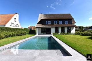 <p><strong>Sunny, Fully Renovated Villa with Pool in the Zoute</strong></p>
<p>Nestled in a prime location in the prestigious residential area of the Zoute, this luxurious detached villa with swimming pool is quietly situated in a cul-de-sac near the Kalfsmolen. Surrounded by greenery, it is just a five-minute drive from the centre of Knokke. The nearby Koningsbos offers a peaceful walk to the beach and Kustlaan.</p>
<p>The villa has been completely stripped and renovated with top-quality materials. It offers exceptional living comfort with 6 bedrooms, 5 bathrooms, and a south-facing garden with a heated pool. An automatic gate leads to the spacious driveway with parking for four cars and an integrated garage.</p>
<p><strong>Layout:</strong> entrance hall with cloakroom and guest toilet, generous living room with parquet flooring, fireplace, and bespoke oak veneer cabinetry, separate dining area with access to the covered terrace and garden. Fully equipped modern kitchen with Miele appliances and marble worktop. Practical laundry room with additional storage space.</p>
<p>The first floor comprises four full-size bedrooms, each with built-in wardrobes and its own bathroom or shower room. The second floor offers two additional spacious bedrooms, a shower room, and a separate toilet on the night hall.</p>
<p>EPC: 198 kWh/m² (UC: 3014336-RES-1).</p>