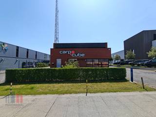 In de gegeerde kleinhandelszone “De Rampe” bevindt zich dit uitzonderlijk commercieel magazijn (985 m²) op een perceel van ca. 1.503 m².<br /><br />Het gebouw werd opgetrokken in een duurzame betonstructuur gecombineerd met een gemetste gevel en een geïsoleerd steeldeck. De ruime overspanning zorgt voor een open en flexibel in te delen ruimte die eenvoudig kan worden aangepast aan diverse activiteiten. <br /><br />Het gelijkvloers, met een oppervlakte van ca. 605 m², omvat het onthaal, een ruime open winkelruimte, stockage en ingericht sanitair. De mezzanine van ca. 380 m² biedt bijkomende uitbreidings- en stockagemogelijkheden en verhoogt hierdoor de commerciële mogelijkheden.<br /><br />Toegang tot het gebouw is via de glazen schuifdeur aan de voorzijde, terwijl leveringen efficiënt verlopen via de automatische sectionale poort aan de achterzijde (ca. 4,45 m breed x 3,25 m hoog).<br /><br />Ook technisch en energetisch is het gebouw uitstekend uitgerust. Het gebouw beschikt gedeeltelijk over een verlaagd plafond, LED-verlichting, dubbele beglazing in aluminium schrijnwerk, verwarming op aardgas via luchtblazers in de winkelruimte en een alarmsysteem in combinatie met winkelpoortjes voor optimale beveiliging.<br /><br />Daarnaast werd sterk ingezet op duurzaamheid en energie-efficiëntie dankzij de aanwezigheid van zonnepanelen met een totaalvermogen van 16.150 Wp en een omvormer van 10 kW. Verder zijn een regenwaterput van 10.000 liter en aansluiting op stadswater voorzien. Optioneel kunnen bovendien de 27 aanwezige beveiligingscamera’s worden overgenomen.<br /><br />Voor extra comfort beschikt dit bedrijfsgebouw eveneens over een functionele keuken en afzonderlijke sanitaire voorzieningen.<br />De volledig verharde site is verzorgd aangelegd met een groenzone en biedt maar liefst 17 parkeerplaatsen aan de voor- en zijkanten van het gebouw. Aan de buitenzijde is extra inbraakbeveiliging voorzien via ramblokken. Dit zorgt niet alleen voor een professionele uitstraling, maar garandeert eveneens voldoende parkeergelegenheid voor klanten en personeel.<br /><br />Dankzij de uitstekende ligging, de ruime parkeermogelijkheden en de kwalitatieve afwerking vormt dit gebouw een ideale uitvalsbasis voor retail-, showroom- of grootschalige kleinhandelsactiviteiten.<br /><br />Gelegen op amper 150m van de Brugsestraat met een onmiddellijke verbinding naast de E40 via de op- en afrit 9 Oostkamp. De kruising met de E403 bereikt men na 3 km.<br /><br />Contacteer PANORAMA B2B voor meer inlichtingen, plannen of een vrijblijvend plaatbezoek 0476 215 115.
