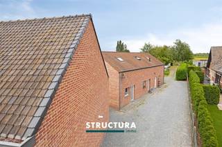 Welkom op deze uitzonderlijke eigendom in Buggenhout, waar wonen, gastvrijheid en veelzijdigheid samenkomen op een prachtig perceel van maar liefst 21a69ca. Deze karaktervolle ééngezinswoning onderscheidt zich door haar unieke indeling met een ruime hoofdwoning én een bijgebouw momenteel ingericht als drie duplex-gastenverblijven waarvan de vergunning op heden vervallen is.De hoofdwoning biedt royale en lichtrijke leefruimtes met een warme, uitnodigende sfeer. Grote raampartijen zorgen voor een aangename lichtinval, terwijl de volledig uitgeruste keuken alle comfort biedt voor dagelijks gebruik. Dankzij de praktische indeling en de verzorgde afwerking geniet u hier van een aangename woonkwaliteit in een rustige, landelijke omgeving.Een absolute meerwaarde vormt de mogelijkheid om het bijgebouw uit te baten als drie duplex-gastenverblijven mits het bekomen van de vereiste vergunningen, elk met een eigen karakter en ingericht om gasten of familie comfortabel te ontvangen. Buiten geniet u van een uitgestrekt terrein met veel groen, privacy en rust. De ruime tuin vormt de ideale omgeving om te ontspannen, gasten te ontvangen of verder in te richten naar eigen wens. De landelijke ligging zorgt voor een aangename woonomgeving, terwijl winkels, scholen en belangrijke invalswegen vlot bereikbaar blijven.Deze eigendom is een zeldzame opportuniteit voor wie op zoek is naar een woning met extra woon- of exploitatiemogelijkheden, veel ruimte en een unieke combinatie van comfort, karakter en potentieel in het hart van Buggenhout.Bestuursmaatregelen in het maatregelenregister: nee