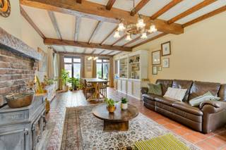 Deze ruime woning met maar liefst 5 slaapkamers geniet van een rustige en groene ligging en biedt tegelijkertijd een vlotte verbinding naar de omliggende gemeenten. Dankzij de royale ruimtes en praktische indeling is dit een ideale gezinswoning met tal van mogelijkheden.<br /><br />Via de inkomhal komen we in de ruime en lichtrijke woonkamer, die mooi is opgedeeld in een gezellige zithoek en een aangename eethoek. Aansluitend bevindt zich de keuken, die voorzien is van een oven, microgolfoven, kookplaat, wastafel, koelkast, vaatwasser, afzuigkap en voldoende kastruimte.<br /><br />De nachthal op het gelijkvloers geeft toegang tot de volledig betegelde badkamer, uitgerust met zowel een bad als een douche. Verder bevinden zich op deze verdieping een afzonderlijk toilet, drie slaapkamers en een ruime inpandige garage met bijkomende bergruimte.<br /><br />De verdieping biedt bijzonder veel mogelijkheden dankzij de zeer ruime polyvalente ruimte. Deze doet momenteel dienst als een extra woonkamer, maar kan naargelang de behoeften perfect ingericht worden als hobbyruimte, speelruimte, bureau, ontspanningsruimte of extra leefruimte.<br /><br />Daarnaast beschikt de verdieping nog over twee ruime slaapkamers en een afzonderlijk toilet.<br /><br />De tuin is sfeervol aangelegd en beschikt over een ruim, deels overdekt terras. Daarnaast biedt de gezellige tuinkamer de ideale plek om in alle rust te genieten van het groen.<br /><br />Een bijkomende troef is de ruime garage met carport en bijhorende berging, die zorgt voor voldoende parkeergelegenheid en extra opbergruimte.