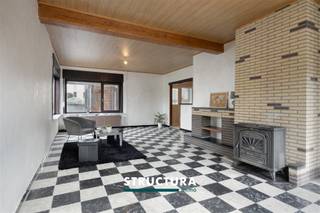 Gezinswoning met 4 slaapkamers in rustige, doodlopende straat te MerchtemBent u op zoek naar een ruime gezinswoning met potentieel, gelegen op een rustige locatie nabij alle voorzieningen? Dan is deze halfopen bebouwing in een doodlopende straat zeker een bezoek waard. Met een bewoonbare oppervlakte van ca. 149 m², vier slaapkamers, een conforme elektrische installatie en een aangename ligging op wandelafstand van het centrum van Merchtem, winkels, scholen en openbaar vervoer, biedt deze woning een uitstekende basis. IndelingGelijkvloers: een inkomhal, een badkamer met douche, lavabo en toilet, een ruime en lichtrijke leefruimte met kachel, gevolgd door een aparte keuken met toegang naar buiten. Achteraan bevindt zich nog een praktische bergplaats. De indeling van het gelijkvloers biedt tal van mogelijkheden voor verdere modernisering en optimalisatie.De eerste verdieping omvat vier volwaardige slaapkamers, ideaal voor een gezin of voor wie extra ruimte zoekt voor een bureau of hobbykamer. Via een valtrap bereikt u de ruime zolderverdieping, die momenteel dienstdoet als bergruimte maar potentieel biedt voor verdere inrichting.Buiten geniet u van een onderhoudsvriendelijke voortuin, een privatieve oprit en een aangename buitenruimte rondom de woning.Karakteristieken- Halfopen bebouwing- Bewoonbare oppervlakte: ca. 149 m²- Perceeloppervlakte: 2a29ca- Rustige ligging in een doodlopende straat- Conforme elektrische installatie- Rolluiken aanwezig- EPC-label F – renovatieverplichting van toepassing binnen de 6 jaar na aankoop- Veel potentieel voor wie de woning naar eigen smaak wenst op te frissen- Maatregelen in het maatregelenregister: neeDeze woning combineert een rustige en kindvriendelijke ligging met een verrassend ruime indeling en tal van mogelijkheden. Dankzij de conforme elektriciteit, vier slaapkamers en de uitbreidbare zolder vormt dit een interessante opportuniteit voor gezinnen, investeerders of handige kopers die op zoek zijn naar een woning met potentieel. Contacteer Structura voor meer informatie of een bezoek ter plaatse via 02 460 80 46 of info@structura.be
