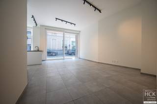 <strong>De ligging</strong><br />Dit <strong>nieuwbouwappartement </strong>(bouwjaar 2024) maakt deel uit van <strong>residentie 'Porta Klara'</strong>, gebouwd op de hoek van de Tolpoortstraat en de Achiel van Eechautestraat. Op amper 3 min. wandelen bereikt u het station van Deinze. Rondom de residentie zijn er allerhande winkels, horecazaken en overige faciliteiten ter beschikking waardoor u alles op <strong>wandel-/fietsafstand </strong>kan bereiken. Dankzij de vlotte verbinding met het op- & afrittencomplex van de E17 (afrit 7 Deinze) zijn centrumsteden Gent-Kortrijk beiden op respectievelijk 20 à 30 min. bereikbaar. <strong>Kortom, hier woont u comfortabel in het hart van Deinze!</strong><br /><br /><strong>De residentie</strong><br />Porta Klara is een <strong>tijdloos nieuwbouwproject</strong> dat zich naadloos integreert in de stedelijke context. Zo werd er gekozen voor verticaliteit in de gevel en werd de plafondhoogte op het gelijkvloers hoger voorzien opdat deze als een 'sokkel' wordt benadrukt. Om het tijdloze karakter van het gebouw te benadrukken, werd gekozen voor een grijze gevelsteen. Als aanvullend materiaal, werd geopteerd voor een donkerkleurig latwerk. Dit zorgt voor een extra warmte en hedendaagse touch aan het geheel. <strong>Porta Klara is dan ook een eyecatcher!</strong><br /><br /><strong>Het appartement</strong><br />Het appartement zelf is gelegen op het <strong>gelijkvloerse verdiep </strong>van het gebouw, een lift is aanwezig (om de autostaanplaats en kelderberging te bereiken). De bewoonbare oppervlakte bedraagt ca 114 m² (inclusief 2 terrassen). Er is ondermeer een ruime en lichtrijke leefruimte aanwezig met aansluitend terras aan straatzijde, een praktische keukenberging, alsmede 2 slaapkamers, badkamer en afzonderlijk toilet alsook een tweede terras palend aan de slaapkamer. In de kelderverdieping van het gebouw beschikt u bijkomend over een<strong> privatieve parkeerplaats én privatieve berging inbegrepen in de huurprijs</strong>. <br /><br /><strong>Kenmerken</strong><br />- Bewoonbare oppervlakte: ca 88 m²<br />- Oppervlakte terrassen: 3,5 m² en 22 m²<br />- Ramen bijkomend voorzien van vliegramen<br /><strong>- Volledig geschilderd en voorzien van armaturen</strong><br />- Energiezuinig (voorzien van zonnepanelen)<br /><br /><strong>Troeven</strong><br />- Knap appartement in tijdloos nieuwbouwproject!<br />- Energiezuinig!<br />- <strong>Volledig instapklaar (d.w.z. geschilderd, voorzien van armaturen + vliegramen)!</strong><br />- Toplocatie!<br /><br />Beschikbaarheid: 01/01/2027 of onmiddellijk (o.t.k. met huidige huurder)<br /><br />Gemeen. kosten: € 50.00 / maand<br /><br />Voor meer informatie of een bezoek ter plaatse reageer via het contactformulier of stuur naar info@hckinvest.be