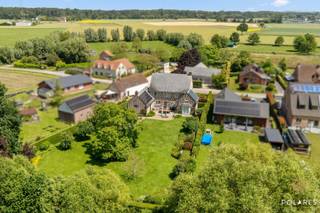 RESERVEER UW BEZOEK VIA www.polares.eu<br /><br />In een residentiële en groene omgeving van Kampenhout bevindt zich deze uitzonderlijke pastorievilla uit 2000, een eigendom waar architecturale elegantie, hoogwaardige afwerking en hedendaagse energieprestaties elkaar in perfecte harmonie ontmoeten. Met een gunstig EPC B, zonnepanelen, laadvoorziening en duurzame technieken bewijst deze villa dat exclusief wonen en toekomstgericht comfort hand in hand gaan.<br /><br />Vanaf het moment dat u de woning betreedt, wordt duidelijk dat hier geen enkel detail aan het toeval werd overgelaten. De imposante inkomhal straalt grandeur uit en vormt het stijlvolle visitekaartje van de woning. Hoogwaardige materialen, een doordachte indeling en verfijnde afwerkingsdetails creëren onmiddellijk een gevoel van klasse en exclusiviteit.<br /><br />De leefruimte is ronduit indrukwekkend. Grote raampartijen laten het daglicht overvloedig binnenstromen en bieden prachtige zichten op de omliggende tuin. De royale volumes, gecombineerd met een elegante open haard, zorgen voor een warme en uitnodigende sfeer waarin luxe en gezelligheid naadloos samenkomen. Elke ruimte werd ontworpen met oog voor esthetiek, comfort en een uitzonderlijke woonbeleving.<br /><br />De keuken vormt het kloppende hart van de woning, kwalitatieve toestellen en een doordachte inrichting maken van deze ruimte een droom voor elke liefhebber van koken en gastvrij ontvangen.<br /><br />Aansluitend bevindt zich een ruime berging die perfect inspeelt op de praktische noden van het dagelijkse leven. Op het gelijkvloers werd bovendien een stijlvolle douchekamer geïntegreerd, ideaal na een sportieve activiteit, een fietstocht of een dag genieten in de tuin.<br /><br />Op de verdieping ontvouwt zich een exclusief nachtgedeelte waar rust, comfort en privacy centraal staan. De luxueuze master suite beschikt over een elegante dressing en biedt een ware hotelsuitebeleving. Daarnaast vervolledigen twee royale slaapkamers en twee smaakvol afgewerkte badkamers deze verdieping. Ook hier getuigt elk detail van vakmanschap en een compromisloze keuze voor kwaliteit.<br /><br />De zolderverdieping biedt een uitzonderlijk potentieel dankzij haar indrukwekkende volume en overvloedige lichtinval. Of u droomt van extra slaapkamers, een exclusieve thuiswerkplek, een privéfitness, bibliotheek of wellnessruimte, deze verdieping laat alle mogelijkheden open om uw levensstijl verder vorm te geven.<br /><br />Boven de garage bevindt zich een aparte polyvalente ruimte die zich perfect leent tot het creëren van een zelfstandige studio, gastenverblijf, praktijkruimte of luxueus thuiskantoor. Een waardevolle extra die het exclusieve karakter van deze eigendom nog verder versterkt.<br /><br />Ook op technisch vlak onderscheidt deze villa zich. Ondanks haar tijdloze architectuur werd steeds geïnvesteerd in duurzaamheid en energie-efficiëntie. Het resultaat is een woning met een gunstig EPC B, voorzien van zonnepanelen, laadpaal en moderne installaties die bijdragen aan een comfortabel, energiezuinig en toekomstbestendig wooncomfort.<br /><br />Buiten wacht een prachtig aangelegde tuin die volledige privacy en sereniteit biedt. Hier vloeien binnen- en buitenleven moeiteloos in elkaar over en geniet u van een unieke woonomgeving waar rust, natuur en exclusiviteit centraal staan.<br /><br />Deze villa is meer dan een woning; het is een eigendom waar luxe voelbaar is in elk detail, waar kwaliteit zichtbaar is in iedere afwerking en waar energiezuinigheid perfect samengaat met een uitzonderlijke woonbeleving.<br /><br />Een zeldzame residentiële parel voor wie enkel genoegen neemt met het allerbeste.
