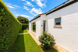 CHARMANTE VAKANTIEBUNGALOW IN MIDDELKERKE – UW PERFECTE TOEVLUCHTSOORD AAN DE KUSTOntdek deze prachtige gelijkvloerse bungalow in de rustige woonwijk van Middelkerke, ideaal voor vakantieverhuur of als bestemming voor een rustig uitje. Met een totale woonoppervlakte van 67 m² biedt deze goed ontworpen woning comfort en functionaliteit op een compact oppervlak.HOOGTEPUNTEN VAN HET INTERIEURDe open leefruimte combineert naadloos de woonkamer, de eethoek en de volledig uitgeruste keuken, waardoor een uitnodigende en gezellige sfeer ontstaat. De lichte, ruime kamers worden overspoeld met natuurlijk licht dankzij royale ramen en glazen schuifdeuren die direct uitkomen op het eigen buitenterras. De moderne keuken is voorzien van hoogwaardige kasten met houten accenten, praktische werkbladen en alle benodigde apparatuur, waaronder een gaskookplaat, magnetron en koelkast.De woonkamer is voorzien van warme terracottategels en ingericht met comfortabele zitopstellingen, perfect om te ontspannen. Een charmante houten vitrinekast en een entertainmentopstelling geven de ruimte karakter en warmte.SLAAPMOGELIJKHEDENDe bungalow beschikt over twee gezellige slaapkamers met comfortabel beddengoed, die gasten een rustgevende overnachting bieden. De eerste slaapkamer is voorzien van een tweepersoonsbed, terwijl de tweede slaapkamer een andere slaapopstelling biedt. Beide kamers profiteren van natuurlijk licht en een aangenaam uitzicht.BADKAMEREen goed uitgeruste, moderne badkamer met een groot bad, een aparte inloopdouche met glazen wanden en hoogwaardige afwerking zorgt voor comfort en gemak voor de gasten. Tot de praktische voorzieningen behoort een wasmachine voor langere verblijven.BUITENRUIMTEDe woning beschikt over een ruim privéterras en een tuin, omgeven door goed onderhouden heggen, die privacy en een rustig toevluchtsoord in de buitenlucht bieden. Het zonnige terras is perfect om buiten te dineren en te ontspannen, met ruim plaats voor tuinmeubilair en gezellig samenzijn.KENMERKEN VAN DE WONINGDe moderne witte gevelbekleding met professionele afwerking geeft de bungalow een frisse, eigentijdse uitstraling. De woning ligt op een rustige, goed bereikbare locatie met parkeergelegenheid in de buurt. De volgroeide beplanting met weelderig groen versterkt de rustige sfeer en biedt uitstekende privacy.Gelegen in Middelkerke geniet u van de nabijheid van de attracties van de Belgische kust, terwijl u toch in een rustige, residentiële omgeving verblijft. Deze woning biedt een uitstekende kans voor wie op zoek is naar een goed onderhouden, instapklare vakantieaccommodatie of een vastgoedbelegging.Daarnaast is de woning voorzien van een parkeerplaats.