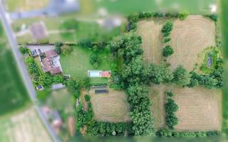 <p><span>Bent u op zoek naar een unieke eigendom waar rust, privacy en ruimte harmonieus samenkomen? Dan zal deze uitzonderlijke landelijke villa in het hart van het glooiende Waaslandse landschap u ongetwijfeld weten te bekoren.</span></p><p><span> </span></p><p><span>Verscholen op de tweede bouwlijn en omringd door prachtige volwassen bomen strekt deze exclusieve eigendom zich uit over maar liefst ruim 2 hectare. De zeldzame combinatie van een idyllische, groene omgeving en een uitstekende bereikbaarheid maakt van dit domein een absolute buitenkans.</span></p><p><span> </span></p><p><span>De belangrijkste troeven in een notendop:</span></p><ul><li><span>Exclusief domein van 21.677 m² met aangelegde tuin, weilanden, zwembad en poolhouse.</span></li><li><span>Toplocatie: uiterst rustig gelegen en toch op slechts 3 minuten van de oprit van de E17, met een vlotte verbinding naar Gent, Antwerpen en Brussel.</span></li><li><span>Prachtige beplanting met waardevolle bomen en een sfeervolle vijver.</span></li><li><span>Zeer ruime villa met een bewoonbare oppervlakte van ca. 500 m².</span></li><li><span>6 slaapkamers en 2 badkamers.</span></li><li><span>Perfecte zuidwestoriëntatie </span></li></ul><p><span> </span></p><p><span>Via de oprijlaan bereikt u deze karaktervolle villa, die in 1979 degelijk werd gebouwd en doorheen de jaren met zorg werd onderhouden, gemoderniseerd en energetisch geoptimaliseerd.</span></p><p><span> </span></p><p><span>Het gelijkvloers verwelkomt u met een royale inkomhal die toegang biedt tot de leefruimtes. De aparte keuken sluit naadloos aan op de eetplaats en de gezellige zithoek met open haard. Daarnaast is er een afzonderlijke bureauhoek voorzien. Via de grote raampartijen heeft u directe toegang tot het zonnige terras en prachtig zicht op groen, waar binnen en buiten moeiteloos in elkaar overvloeien. Verder beschikt deze verdieping over een praktische koele berging en drie garages.</span></p><p><span> </span></p><p><span>Op de eerste verdieping bevinden zich vier ruime slaapkamers en een grote polyvalente ruimte die zich perfect leent als royale master bedroom, praktijkruimte, aparte bureauruimte of conciërge-/nannyverblijf. Dankzij de mogelijkheid om een bijkomende trap met eigen toegang te voorzien, biedt deze ruimte tal van interessante invullingen.</span></p><p><span> </span></p><p><span>De tweede verdieping vervolledigt het geheel met nog twee bijkomende slaapkamers.</span></p><p><span> </span></p><p><span>Het uitgestrekte domein vormt zonder twijfel één van de absolute blikvangers van deze eigendom. De prachtige volwassen bomen creëren een uniek en groen kader, terwijl het vergunde zwembad met poolhouse uitnodigt om volop te genieten van het buitenleven. </span></p><p><span> </span></p><p><span>Dankzij de ideale zuidwestoriëntatie geniet u hier de hele dag van de zon.</span></p><p><span> </span></p><p><span> De weilanden bieden bovendien tal van mogelijkheden voor paardenliefhebbers of voor wie graag omringd wordt door natuur en openheid.</span></p><p><span> </span></p><p><span>Doorheen de jaren werden verschillende energiebesparende investeringen uitgevoerd, waaronder spouw-, dak- en kelderisolatie alsook hoogrendementsbeglazing.</span></p><p><span> </span></p><p><span>Bent u klaar om het unieke karakter en de uitzonderlijke ligging van deze eigendom zelf te ontdekken? Neem dan vrijblijvend contact op voor een bezoek via <span>pieter@axellenaerts.be</span></span><span>.</span></p>