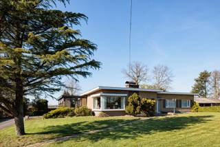 Meer info en bezoeken: 0485/321.842<br />Gelegen tegen de grens met Nederland en in het prachtige polder- en krekengebied, geniet deze eigendom van een uitzonderlijk mooie ligging. Op zo'n 4km buiten de centra van Wachtebeke en Zelzate bevindt zich deze woning met bijgebouwen. De woning en het magazijn werden gebouwd in 1965-66, de garage volgde kort nadien. De woning en de tuin hebben een zeer goede staat van onderhoud. Ondanks de ouderdom van het gebouw is zowel het interieur als het exterieur steeds met veel zorg onderhouden. De bouwtechnische staat is ook nog zeer goed, al zullen renovaties van o.m. het dak, isolatie, technieken en sanitair zich opdringen. Met een bewoonbare oppervlakte van 217m2 en met 4 slaapkamers is de woning ook nog steeds hedendaags wat de indeling betreft. De kamers zijn ruim, er is meer dan voldoende bergruimte en de leefruimtes zijn gericht naar de zonnekant. De garage achter de woning is zo'n 75m2, het magazijn heeft een oppervlakte van 250m2 en ook een praktische hoogte. Een groot voordeel is dat deze gebouwen nooit een landbouwfunctie hadden en ze dus ook reeds als een woning en woningbijgebouwen gekend zijn. De bestemming van de percelen is valleigebied, dit houdt in dat er mag verbouwd worden binnen het bestaande volume, maar slopen en heropbouwen en uitbreiden worden hier uitgesloten. een prachtig project voor mensen die op zoek zijn naar rust ruimte, natuur en nuttige oppervlakte!