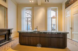 Tussen de mooiste kerk van Brugge, de Walburgakerk, en het Europacollege situeert zich dit exclusief woonappartement. Het geniet royale woongelegenheden, hoge plafonds, historische elementen zoals statige molurus en lederen wandbekleding. Het is niet moeilijk om lyrisch te worden over de troeven van deze monumentale eigendom.<br />Het appartement situeert zich op het gelijkvloers niveau van de Res. Huis Van Hamme en geniet een bewoonbare oppervlakte van maar liefst 221 m², 31 m² aan terras, een privé inkomhal, gashaarden, royaal salon, een volledig geïnstalleerde keuken (Obumex), 2 slaapkamers (of bureel), privé afgesloten garagebox en een extra berging.<br /><br />Het geniet een high -end afwerking (Obumex) en biedt tal van mogelijkheden (residentieel appartement; kantoor).