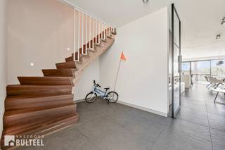In een landelijke omgeving vindt u deze duurzame, kwaliteitsvolle en moderne BEN-nieuwbouwwoning van 2024, gebouwd volgens de strengste energienormen en uitgerust met alle moderne technische voorzieningen. De woning biedt u op het gelijkvloers een inkomhal, een berging, een apart toilet, een lichtrijke living, een moderne, tijdloze en volledig uitgeruste keuken met quooker kraan en een grote berging/wasplaats. Op de eerste verdieping zijn er 2 slaapkamers waarvan 1 met op maat gemaakte dressing, een apart toilet en een badkamer met inloopdouche, bad en dubbele lavabo. Op de tweede verdieping zijn er nog 2 grote slaapkamers en een ruime zolder met schuiftrap. Leuk terras en tuin met zicht op de achterliggende weilanden. Carport voorzien van elektriciteit. Gemeenschappelijke fietsenberging. Bovendien beschikt de woning over de allerlaatste technieken zoals vloerverwarming/koeling met geothermische warmtepomp, 12 zonnepanelen, videofonie, conforme elektriciteit en ventilatiesysteem D. In de nabijheid van diverse fiets- en wandelroutes en recreatiedomein De Ster. Goede verbinding naar E17 en N16. Verkoop onder stelsel van registratierechten. Aarzel dus niet en ontdek samen met ons deze luxueus afgewerkte woning.