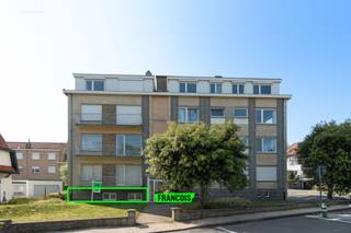 In de gegeerde en bijzonder charmante Concessiewijk van De Haan, op amper 50 meter van het strand, bevindt zich dit lichtrijke gelijkvloersappartement. Het appartement ligt in een rustige residentiële buurt, met vlotte bereikbaarheid en in de onmiddellijke nabijheid van winkels, openbaar vervoer en uiteraard de zee.<br /><br />Via de inkomhal krijgt u toegang tot alle vertrekken in het appartement. De leefruimte is ruim en geniet dankzij de verschillende raampartijen van veel daglicht. Er is voldoende plaats voor zowel een comfortabele zithoek als een eetruimte. Aansluitend bevindt zich de keuken, die in goede staat verkeert en voorzien is van alle hedendaagse benodigdheden. Vanuit de keuken is er bovendien een aparte deur die directe toegang biedt tot de gemeenschappelijke tuin van het complex, wat een extra troef vormt voor wie van buitenruimte houdt.<br /><br />Het appartement beschikt verder over twee volwaardige slaapkamers, een aparte badkamer en een afzonderlijk toilet. Op enkele muren is er wel vochtproblematiek vastgesteld, wat bij renovatie dient te worden aangepakt. Belangrijk om te vermelden is dat er reeds concrete en goedgekeurde plannen zijn om het volledige gebouw te verbouwen. De renovatiewerken zullen van start gaan net na de zomer van 2025 en de oplevering is voorzien tegen eind juni 2026.<br /><br />Deze eigendom biedt dus niet alleen een unieke ligging op een toplocatie aan zee, maar ook het potentieel om verder te worden afgewerkt en gemoderniseerd naar eigen smaak. Dankzij de geplande renovatiewerken aan het gebouw is dit hét ideale moment om in te stappen, zodat u gelijktijdig ook de binnenzijde van het appartement kunt vernieuwen.<br /><br />Bij verdere interesse of vragen over de geplande verbouwingen en mogelijkheden, kan u steeds contact met ons opnemen. Mis deze unieke kans niet om te investeren in een karaktervolle woning aan de Belgische kust, in één van de meest gewilde buurten van De Haan.<br /><br />