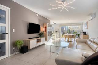 <h1><span>Moderne halfopen bebouwing met tuin en garage in Hove</span></h1><p><span>Op een gunstige locatie aan de Mortselsesteenweg 88 in Hove bevindt zich deze moderne halfopen bebouwing, gekenmerkt door haar strakke architectuur, lichtrijke leefruimtes en verzorgde afwerking.</span></p><p><span>Bij het betreden van de woning komt u terecht in de inkomhal, die toegang biedt tot de verschillende ruimtes. De aangename leefruimte is ingericht met een gezellige zithoek en aansluitende eetplaats. Dankzij de grote raampartijen aan de achterzijde geniet de woning van een overvloed aan natuurlijk licht en een mooi zicht op de tuin.</span></p><p><span>Aansluitend bevindt zich de moderne, volledig uitgeruste keuken met strakke witte kasten, een stijlvol werkblad en diverse ingebouwde toestellen. Het praktische kookeiland met zitgelegenheid vormt een mooie aanvulling op deze functionele ruimte. Verder beschikt de woning over een afzonderlijke berging en wasplaats, voorzien van praktische opbergmogelijkheden en ruimte voor wasmachine en droogkast.</span></p><p><span>Op de eerste verdieping bevinden zich de slaapkamers, die dankzij de grote ramen genieten van een aangename lichtinval. De kamers zijn verzorgd afgewerkt met parket en bieden voldoende ruimte voor een comfortabele inrichting.</span></p><p><span>De woning beschikt bovendien over airconditioning in verschillende ruimtes, wat bijdraagt aan het wooncomfort.</span></p><p><span>Buiten geniet u van een aangename, volledig omheinde tuin met een ruim terras en een mooi onderhouden gazon. De groene omheining zorgt voor de nodige privacy. Via de praktische zijdoorgang is de tuin bovendien gemakkelijk bereikbaar. Achteraan bevindt zich een garage met een ruime verharde oprit, die bijkomende parkeermogelijkheden biedt.</span></p><p><span>De woning is gelegen op een gunstige locatie in Hove, met een vlotte verbinding naar Edegem, Mortsel en Antwerpen. Winkels, scholen, openbaar vervoer en andere dagelijkse voorzieningen bevinden zich in de nabije omgeving.</span></p><p><span>Kortom, een moderne en verzorgde gezinswoning met een lichtrijk interieur, praktische indeling, aangename tuin en garage op een gunstige locatie in Hove.</span></p>