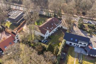 Deze ruime villa bevindt zich op de groene grens van Kalmthout en Brasschaat, in een residentiële omgeving met exclusieve uitstraling. U woont hier vlak bij prachtige natuur- en wandelgebieden en toch bijzonder centraal, met het centrum van Maria-ter-Heide en de oprit van de autostrade binnen handbereik.
Via de statige, groene laan bereikt u de oprit van deze villa. Binnen combineert de woning een modern interieur met authentieke elementen. De inkomhal met imposante houten trap leidt naar een aparte bureauruimte met visgraatparket. Op het GLV vindt u nog de aparte keuken, gezellige zitruimte en salon, badkamer met ligbad, apart toilet en een ruime wasplaats. De indeling leent zich perfect tot zorg- of kangoeroewonen.
Op de 1e verdieping bevinden zich 2 volwaardige slaapkamers op parketvloer, een 2e badkamer met inloopdouche en een apart toilet. De ruime 2e leefruimte met vide vormt een echte blikvanger en biedt tal van mogelijkheden, zoals een speel- of hobbyruimte. Verder is zijn er nog 2 extra slaapkamers. De grote, privatieve tuin met tuinhuis maakt het geheel compleet. 
Kortom, een uitzonderlijk veelzijdige woning in het groen, perfect voor grote gezinnen, zorgwonen of wie wonen en werken wil combineren. Kom zelf de charme en mogelijkheden ontdekken!
Stedenbouwkundige inlichtingen en bodemattest in aanvraag. 
Voor meer informatie of een gratis waardebepaling van uw vastgoed kan u een aanvraag invullen op onze website of even bellen op het nr. 03/345.88.99.
