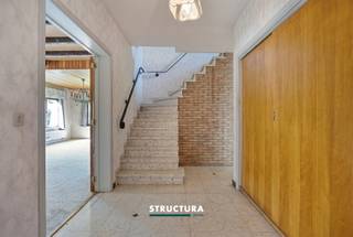 Bent u op zoek naar een ruime gezinswoning die u volledig naar eigen smaak kunt renoveren? Dan is deze vrijstaande villa precies wat u zoekt. Gelegen in een rustige doodlopende straat geniet u hier van alle privacy en een veilige woonomgeving, terwijl u dankzij de vlotte verbinding met de Ring en de A12 toch snel uw bestemming bereikt. Met een perceel van 8a01ca, een bewoonbare oppervlakte van ca. 240 m², vier volwaardige slaapkamers, een grote garage en tal van bergruimtes biedt deze woning een uitstekende basis voor wie ruimte en potentieel weet te waarderen.IndelingGelijkvloers: ruime inkomhal met gastentoilet, lichtrijke leefruimte met gezellige houthaard, aparte keuken, veranda en bureau.Eerste verdieping: nachthal, vier ruime slaapkamers van ca. 18,2 m², 18,7 m², 19,6 m² en 20,54 m² en een badkamer uitgerust met zowel een ligbad als een douche.Zolder: praktische zolderruimte bereikbaar via een valtrap, ideaal als extra bergruimte.Kelder: ruime garage en verschillende kelderruimtes die zorgen voor extra opslagmogelijkheden/werkruimte of ateliermogelijkheden. Buiten: ruime oprit met plaats voor meerdere wagens en een aangenaam perceel van 8a01ca.Karakteristieken- Vrijstaande villa- Rustig gelegen in een doodlopende straat- Bureau op het gelijkvloers- Te renoveren en volledig naar eigen smaak in te richten- Vrij bij akte- Maatregelen in het maatregelenregister: neeDankzij de ruime volumes, de uitstekende ligging en de vele mogelijkheden vormt deze villa de ideale opportuniteit voor gezinnen die op zoek zijn naar een woning met karakter en renovatiepotentieel. Wenst u deze eigendom te ontdekken? Contacteer ons vandaag nog voor meer informatie of plan uw bezoek in via 02 460 80 46 of info@structura.be