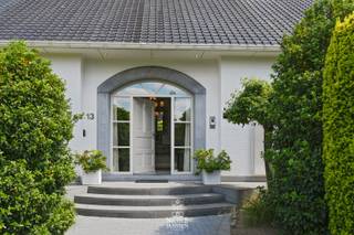 Deze vrijstaande exclusieve villa straalt karakter en comfort uit. Omringd door een fraai aangelegde tuin met verwarmd zwembad en poolhouse biedt deze woning een unieke combinatie van comfort, luxe en ruimte. Dankzij de praktische indeling is wonen op het gelijkvloers perfect mogelijk. De ideale woonplek voor wie houdt van rust en privacy.<br /><br />=> Ligging<br />Deze vrijstaande villa is rustig gelegen in de Derde Straat in Maaseik, een aangename en residentiële buurt. U geniet er van privacy én een vlotte bereikbaarheid. Winkels, scholen en het centrum van Maaseik liggen op korte afstand, terwijl u toch woont in alle rust en groen. <br /><br />=> Gelijkvloers<br />- Royale inkomhal<br />- Apart gastentoilet met fonteintje<br />- Vestiaire <br />- Via de dubbele glazen deur bereikt u de leefruimte<br />- Luchtige leefruimte met veel lichtinval, doorkijk gashaard en toegang tot de tuin<br />- Ingerichte keuken met zicht op en toegang tot het terras<br />- Wasplaats/bijkeuken met vaste kasten en ingebouwde keukentoestellen<br />- Ouderlijke slaapkamer met vaste kasten en ensuite badkamer met ligbad, dubbele wastafel en inbouwkasten<br />- Tweede slaapkamer<br />- Bureelruimte <br />- Dubbel inpandige garage met automatische poorten en extra douchecel<br /><br />=> Verdieping<br />- Overloop met ingebouwde sauna<br />- Derde slaapkamer met douchecel en toilet<br />- Vierde slaapkamer<br />- Technische ruimte met C.V.-ketel op aardgas<br />- Vier zolderruimtes, polyvalent in te richten (hobbyruimte, extra slaapkamers, bureel …)<br /><br />=> Kelder<br />- Kleine voorraadkelder onder de hal<br /><br />=> Tuin<br />- Verzorgde, volledig omheinde tuin rondom de woning<br />- Groot zonneterras met automatische zonneluifel aan de achterzijde<br />- Verwarmd zwembad via warmtepomp<br />- Poolhouse met overdekt terras, ideaal voor ontspanning op zomeravonden<br /><br />=> Indeling:<br />-- Gelijkvloers: inkomhal met vestiaire en apart gastentoilet, woonkamer, keuken, wasplaats/bijkeuken, ouderlijke slaapkamer met ensuite badkamer, tweede slaapkamer, en dubbel inpandige garage;<br />-- Verdieping: overloop met sauna, twee slaapkamers, zolderruimtes en technische ruimte;<br />-- Kelder: voorraadruimte onder de inkomhal.