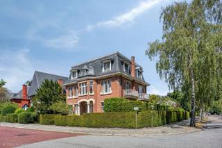 Verkoop op aandelen.<br /><br />Een uitzonderlijke villa waar architectuur, elegantie en hedendaags comfort elkaar ontmoeten.<br /><br />Op een van de meest gegeerde locaties van Wilrijk, verscholen in de prestigieuze villawijk Den Brandt, bevindt zich deze karaktervolle residentie uit het interbellum. Een eigendom met een uitgesproken identiteit, waar historische architectuur en hedendaagse verfijning op een bijzonder natuurlijke manier samenkomen.<br /><br />De villa werd in 1924 ontworpen door de gerenommeerde architecten Gebroeders Wauters en getuigt vandaag nog steeds van de elegante beaux-artsarchitectuur uit die periode. De hoekligging aan de Sorbenlaan en Olmenlaan, de royale proporties en de aanwezigheid van authentieke elementen geven het pand een uitstraling die moeilijk te evenaren is.<br /><br />Achter de statige gevel ontvouwt zich een uitzonderlijk ruime woonbeleving van circa 600 m², met royale leefruimtes, originele parketvloeren, een stijlvolle leef- en eetkeuken en een sterke connectie met de aangelegde tuin.<br /><br />De woning beschikt over vijf slaapkamers, waaronder een bijzonder ruime master suite met dressing en een luxueuze badkamer.<br /><br />De leefkelder vormt een volwaardige ontspanningszone met onder meer een wellnessruimte met sauna en jacuzzi en een eigen home cinema.<br /><br />De tuin biedt, midden in de stad, een gevoel van rust en privacy dat vandaag bijzonder schaars is. De ligging nabij Park Den Brandt en de omliggende groene residentiële lanen combineert een discrete woonomgeving met een vlotte verbinding naar Antwerpen en de belangrijkste uitvalswegen.