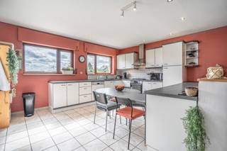 Deze charmante woning is gelegen in Halle. Dankzij de gunstige ligging bevindt de woning zich nabij winkels, scholen, openbaar vervoer en belangrijke invalswegen. Achteraan grenst de tuin bovendien aan een weiland, waardoor u geniet van een aangenaam en groen uitzicht.

We betreden de woning via de inkomhal die toegang geeft tot de verschillende ruimtes. Op het gelijkvloers bevindt zich een badkamer uitgerust met een bad, douche en lavabo, alsook een apart toilet. Verder treffen we hier een slaapkamer aan met de mogelijkheid om de aangrenzende ruimte in te richten als dressing of kinderkamer.

Achteraan komen we terecht in de ruime en lichtrijke leefruimte met eetplaats. Deze staat in directe verbinding met de open keuken, die een mooi uitzicht biedt op de tuin en het achterliggende weiland.

De tuin vormt een aangename buitenruimte en zorgt dankzij de groene omgeving voor een gevoel van rust en privacy. Vooraan beschikt de woning over een oprit met plaats voor twee wagens.

Daarnaast beschikt de woning over een praktische berging met aansluiting voor een wasmachine alsook voldoende opbergruimte.

Op de verdieping bevindt zich nog een derde kamer. De ingerichte zolder biedt bovendien de mogelijkheid om verder ingericht te worden als één of zelfs twee bijkomende kamers, waarvan één als doorloopkamer.
