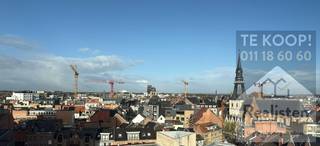 Zicht over de stad heb je, op de achtste verdieping aan het Torenplein<br />Of het is dat en of de ligging pal in het centrum of het ideale formaat van deze pied-à-terre die charmeert.<br /><br />Het appartement heeft 2 slaapkamers, een open keuken aparte living, een badkamer, een apart toilet, een ruime inkomhall en een berging.<br />De ochtendzon staat aan de kant van de grote slaapkamer, de avondzon aan de kant van de kleine slaapkamer, living en keuken.<br /><br />Het appartement dateert van begin jaren '70 en het is helemaal vernieuwd.<br />Alles is nieuw : de vloer, de keuken, de badkamer, de ramen, alles!<br />Het terras aan de living is circa 6m², het terras aan de slaapkamer is circa 4m².<br /><br />Bewoners hebben een gebruiksrecht van de gemene parkeerplaatsen op het privéterrein van het gebouw zelf.<br />Verder is er legio parkeerplaats met bewonerskaar in de onmiddellijke buurt, en ook een ruime publieke fietsenstalling.<br /><br />De vaste kosten bedragen circa €165/maand incl. verwarming en warm water.<br /><br />Meer info?<br />Realisten Makelaars<br />Bel 011 18 60 60