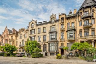 <p><span>BERCHEM - Cogels-Osylei</span><span>: Eclectische herenwoning “De Zwaluwen” met 6 slaapkamers, 3 badkamers, groot bureau, oprit en zuidtuin. </span></p><p><span> </span></p><p><span>Een uitzonderlijke opportuniteit voor liefhebbers van karaktervolle architectuur, erfgoed en stijlvol wonen in de stad. </span></p><p><span> </span></p><p><span>Gelegen aan de iconische Cogels-Osylei bevindt zich deze beschermde karaktervolle herenwoning uit 1904 naar ontwerp van architecten Cols en Defever. Een uniek stukje Antwerpse geschiedenis in het hart van de gegeerde historische wijk Zurenborg. De Cogels-Osylei geldt als het prestigieuze visitekaartje van de wijk en staat bekend om haar indrukwekkende eclectische architectuur, monumentale gevelrijen en uitzonderlijk goed bewaarde belle-époque uitstraling.</span></p><p><span>Wonen op de Cogels-Osylei betekent wonen in één van de mooiste straten van Antwerpen, op wandelafstand van station Berchem, hippe horecazaken, gezellige pleinen en alle stedelijke voorzieningen. De wijk combineert architecturale grandeur met een levendige, residentiële sfeer.</span></p><p><span> </span></p><p><span>BESCHRIJVING:</span></p><p><span> </span></p><p><span>Gelijkvloers</span><span>:</span></p><p><span>Voortuin met oprit en trappen naar het residentiële en professionele gedeelte.Inkomhal op marmer met vestiaire en gastentoilet. Toegang tot de zeer lichte en prachtige living met hoge plafonds en authentieke moulures en schouw. Aanpalende bibliotheek en formele eetplaats. Keuken met eethoek en via prachtige ramen toegang tot het terras en zuidgerichte tuin.</span></p><p><span> </span></p><p><span>Verdiepingen</span><span>: </span></p><p><span>Masterbedroom met open haard, aanpalende dressing met ingemaakte kasten en en-suite badkamer. Verder vinden we nog 5 ruime slaapkamers en 1 tot 2 badkamers.</span></p><p><span> </span></p><p><span>Kelder</span><span>:</span></p><p><span>Polyvalente open ruimte ingericht als kantoor voor vrij beroep in 3 verbonden bureauruimtes met directe toegang aan de straatkant, met op maat gemaakte kasten en bibliotheek en lavabo. Toegang tot terras via schuifdeuren.</span></p><p><span> </span></p><p><span>BIJZONDERHEDEN:</span></p><p><span> </span></p><p><span>*Unieke architectuur op historische toplocatie</span></p><p><span>*Enorm potentieel en behoud van karaktervolle elementen</span></p><p><span>*Mooie zuidgerichte tuin</span></p><p><span>*Oprit</span></p><p><span>*Ideale combinatie wonen/werken</span></p><p><span> </span></p>